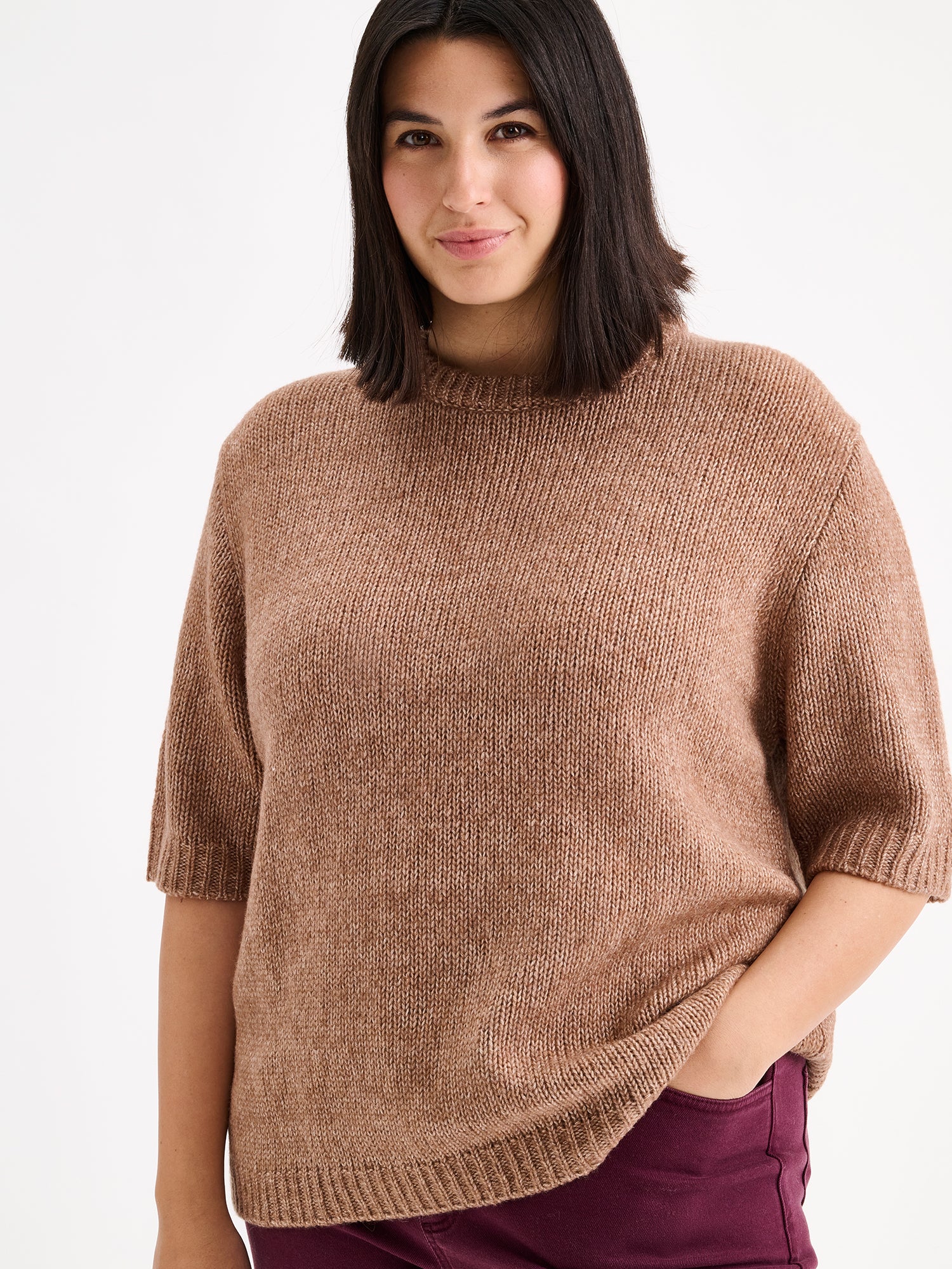 Nanso womens knit sweater Moriko in warm brown, on a model with red jeans, close-up
