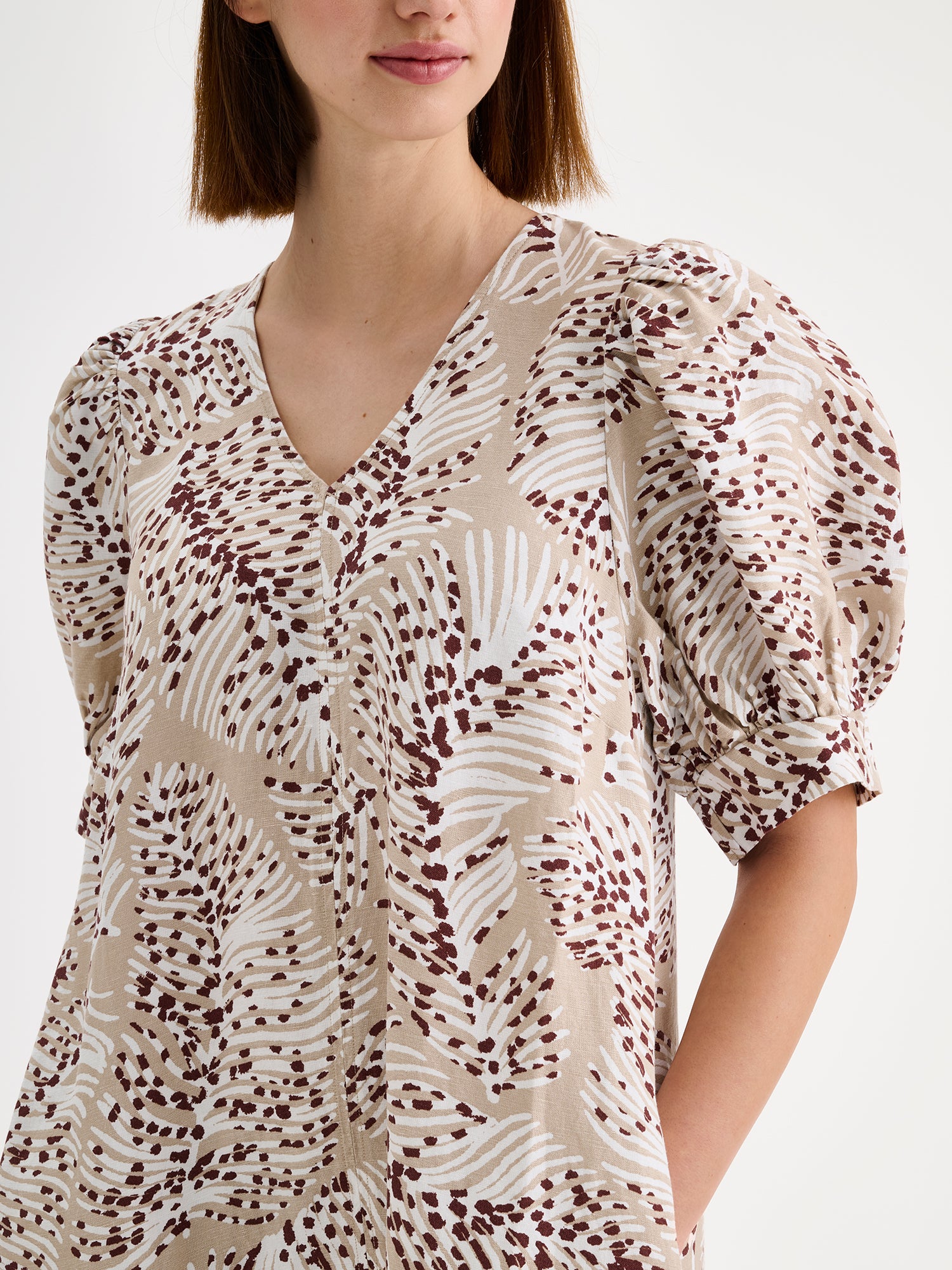 Nanso women's midi Hilde dress in a stylish and delicate beige print on a model, close-up.