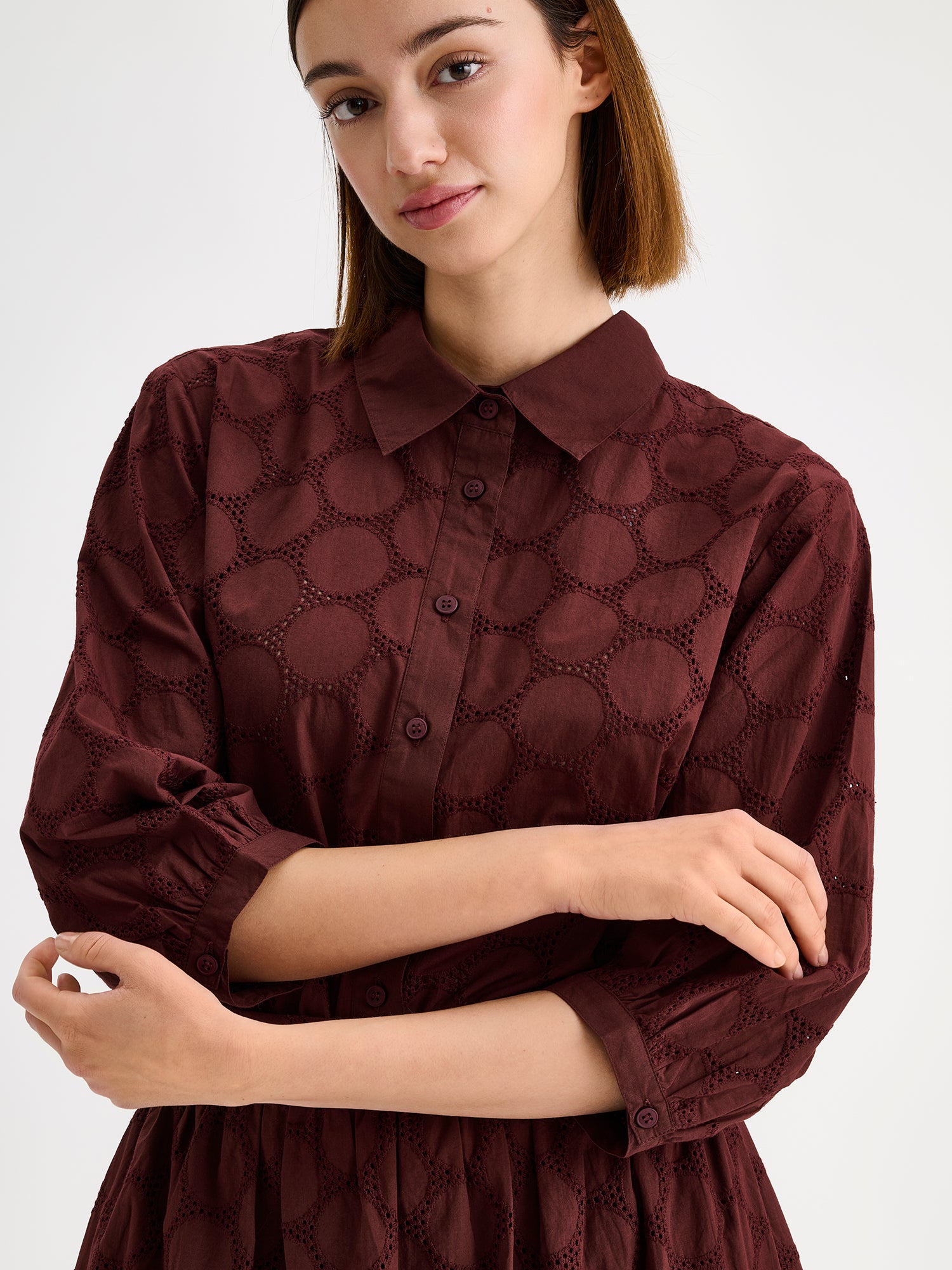 nanso women's stylish dark brown Siiri blouse for women, featuring beautiful embroidered fabric, classic collar, buttons and 3/4 sleeves, on a model with a matching skirt, close-up