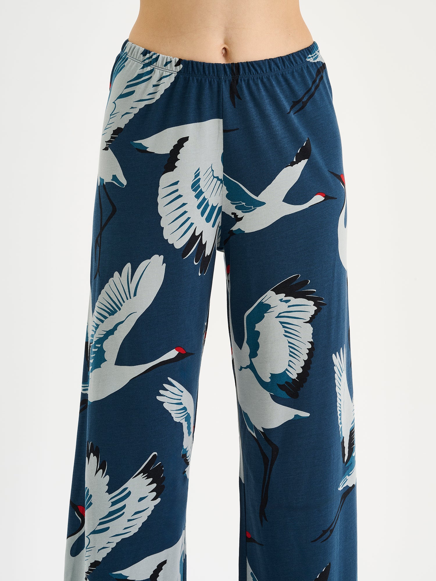 Nanso women's relaxed and loose-fitting Kurki lounge trousers with cropped legs and a charming blue-toned pattern on a model close-up.