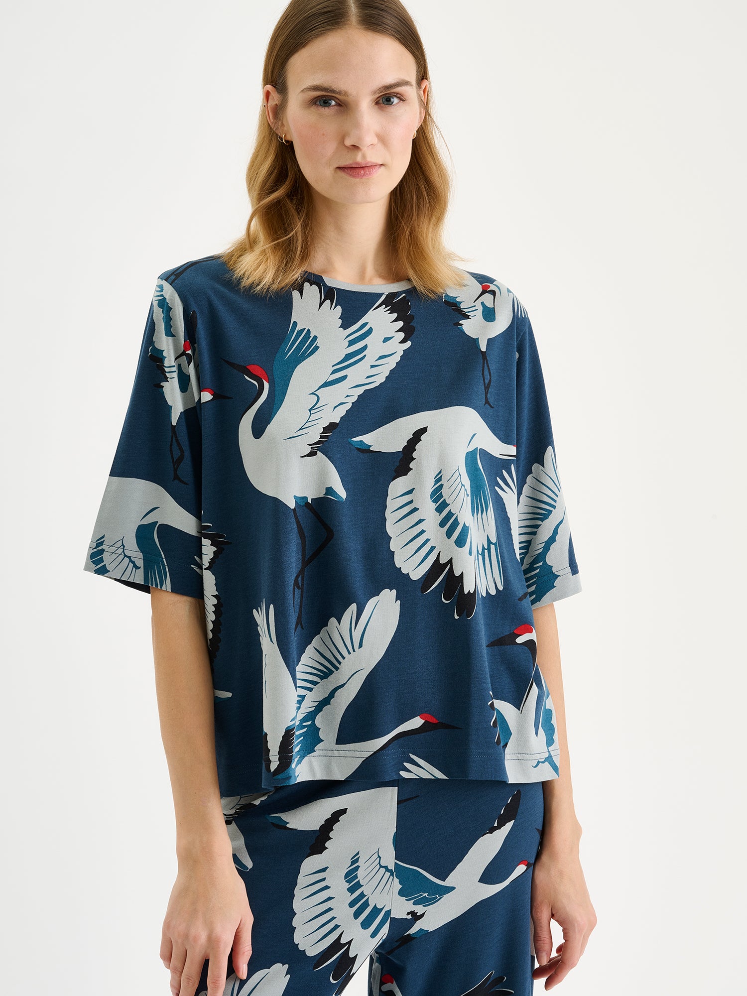 Nanso women's relaxed and straight-cut women's loungewear t-shirt featuring a charming Kurki pattern in elegant blue on a model with matching pants, close-up
