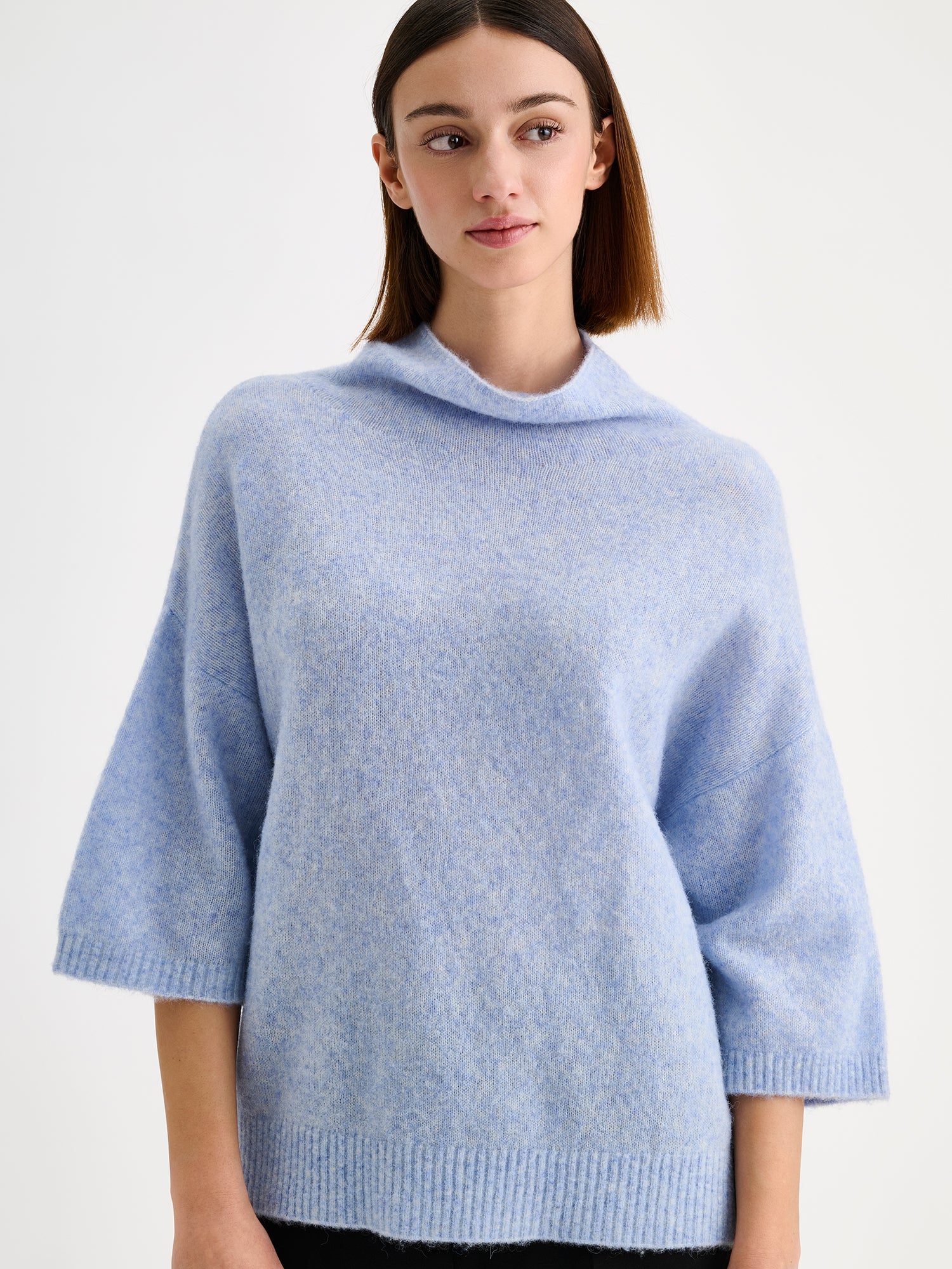 Nanso women's relaxed Alina knit sweater with a high neckline on a model with black trousers | S - 173m