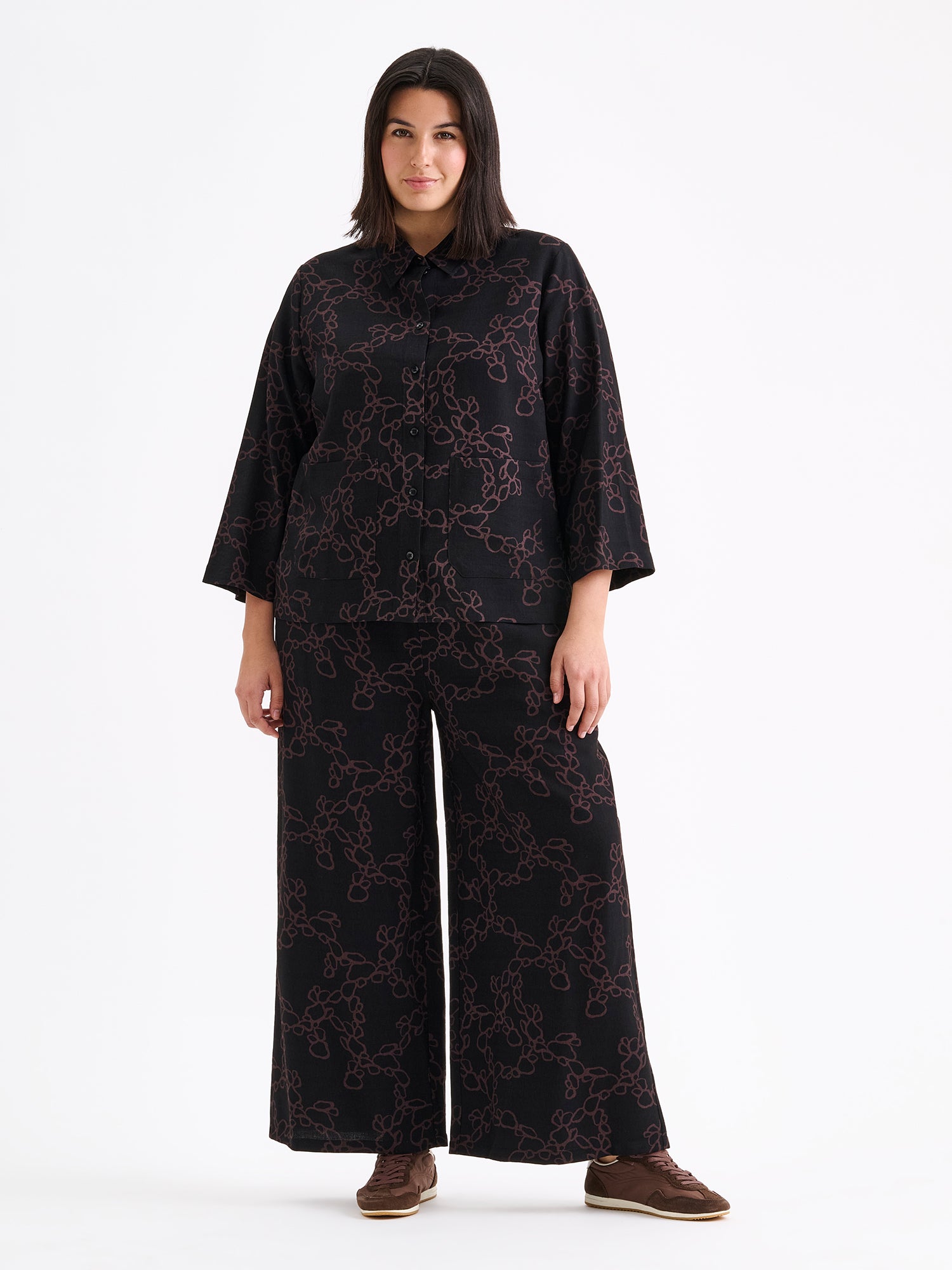 Women's patterned black and brown KIDE shirt and wide trousers on a model