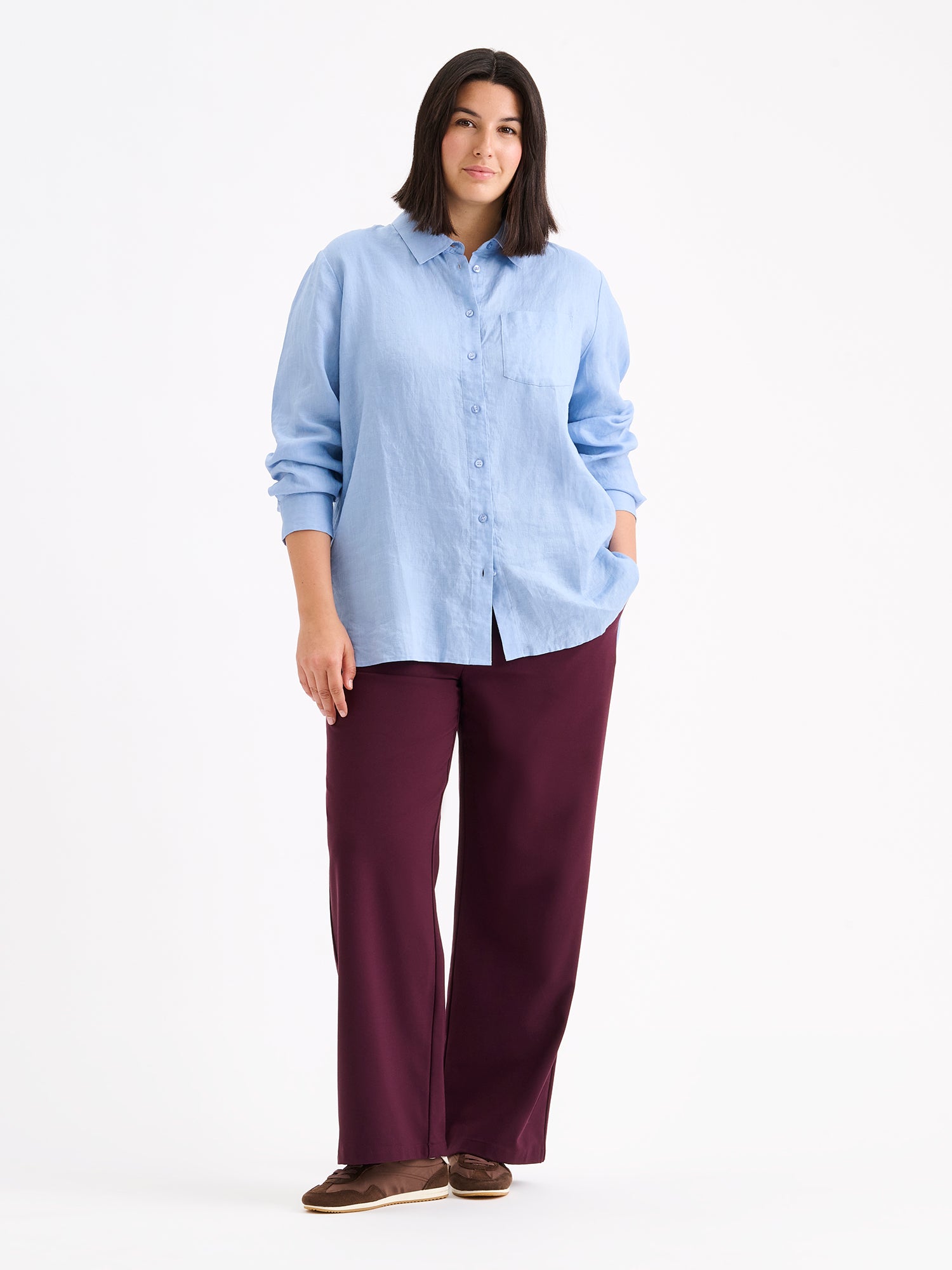 Nanso women's relaxed, classic and versatile light blue Lene linen shirt is crafted from woven linen fabric that is durable and breathable. The shirt features a front button closure and chest pocket and full-length sleeves. Pictured on a model