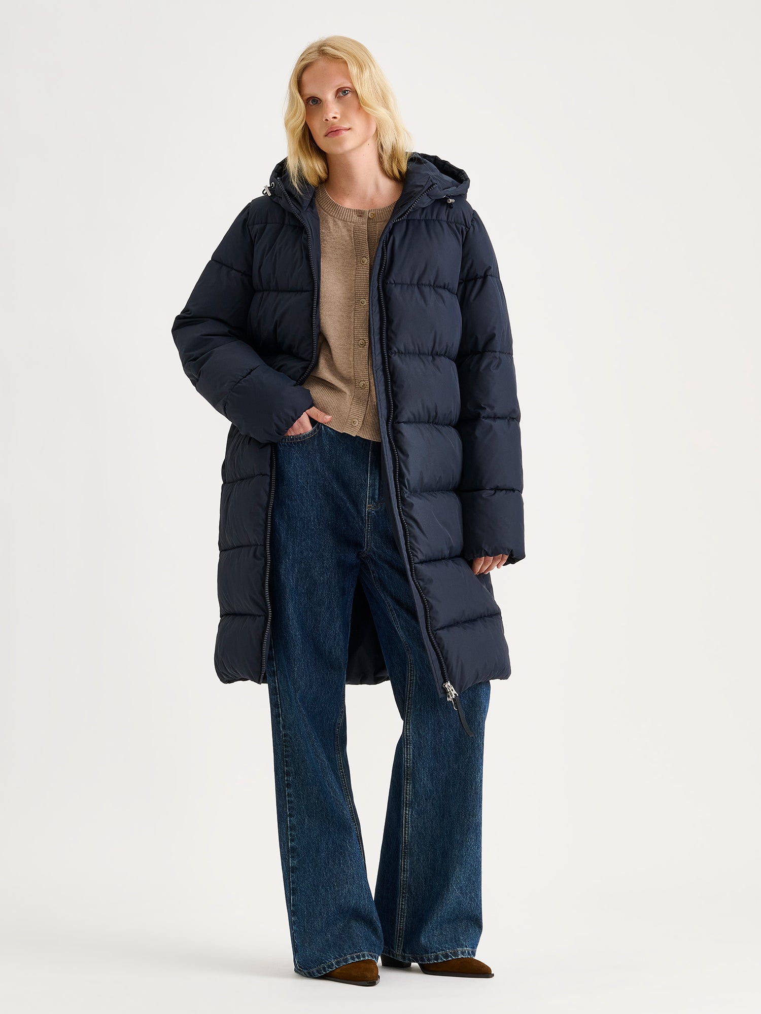 Nanso women's warm, padded yet pleasantly lightweight Lumi midi puffer coat in dark blue on a model.