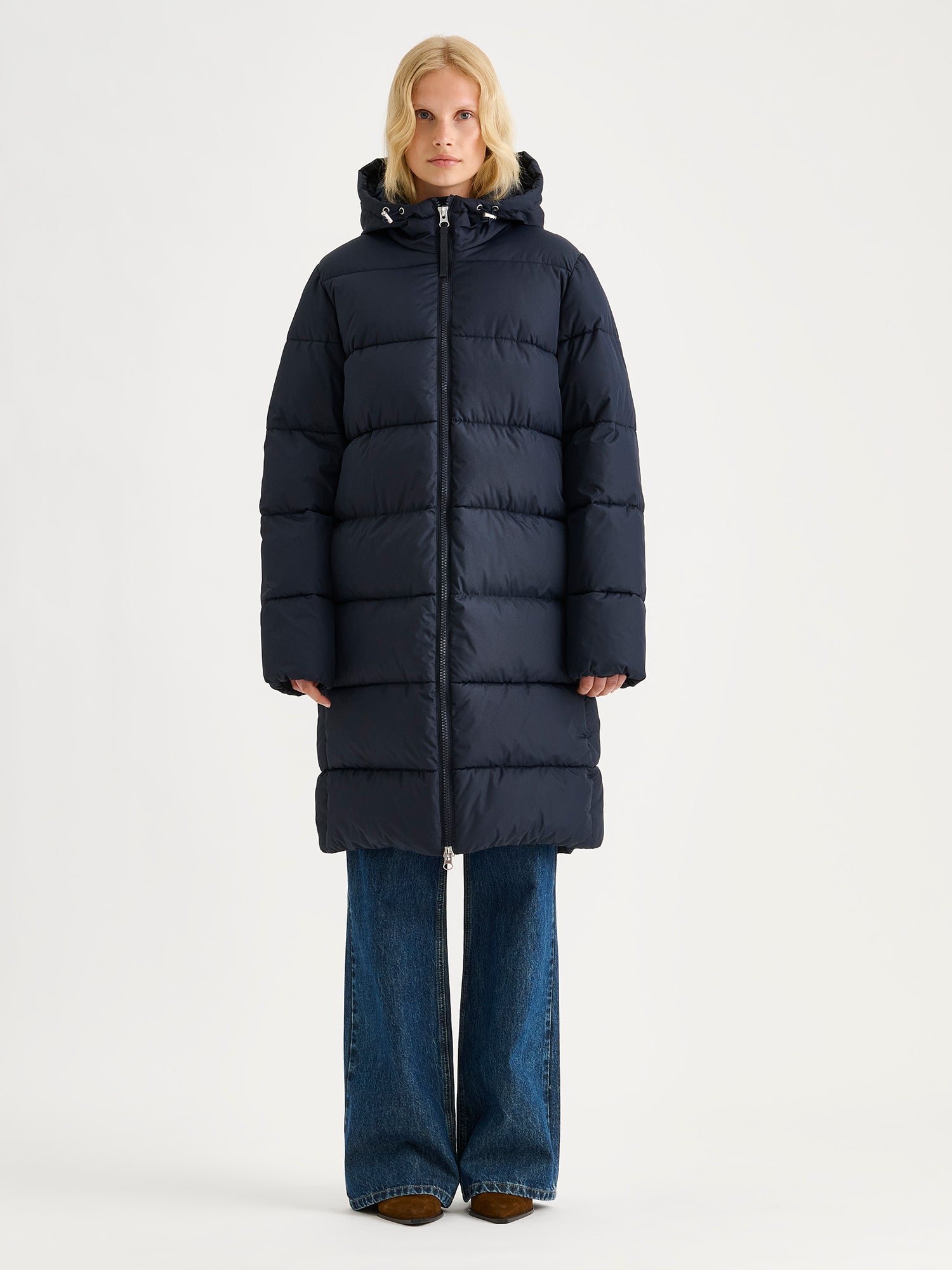 Nanso women's warm, padded yet pleasantly lightweight Lumi midi puffer coat in dark blue on a model.