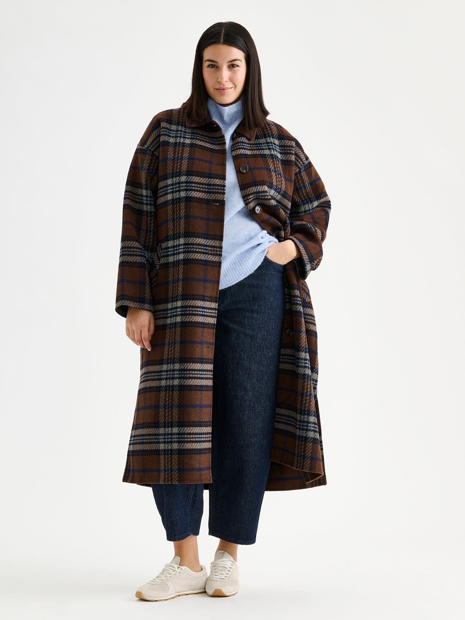 The stylish and timeless Astrid wool coat features a contemporary checked pattern, pictured on a model 