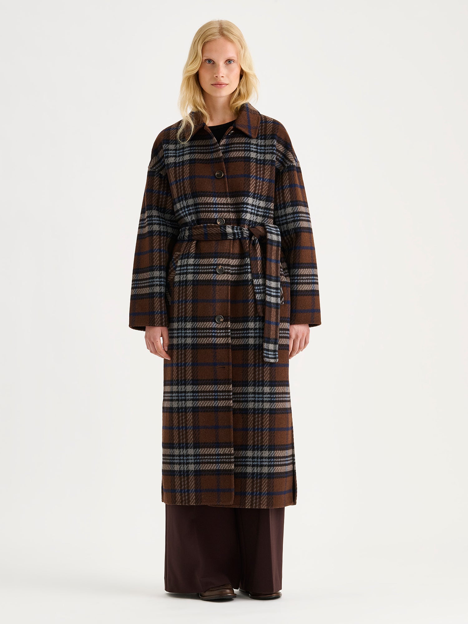 The stylish and timeless Astrid wool coat features a contemporary checked pattern, pictured on a model 