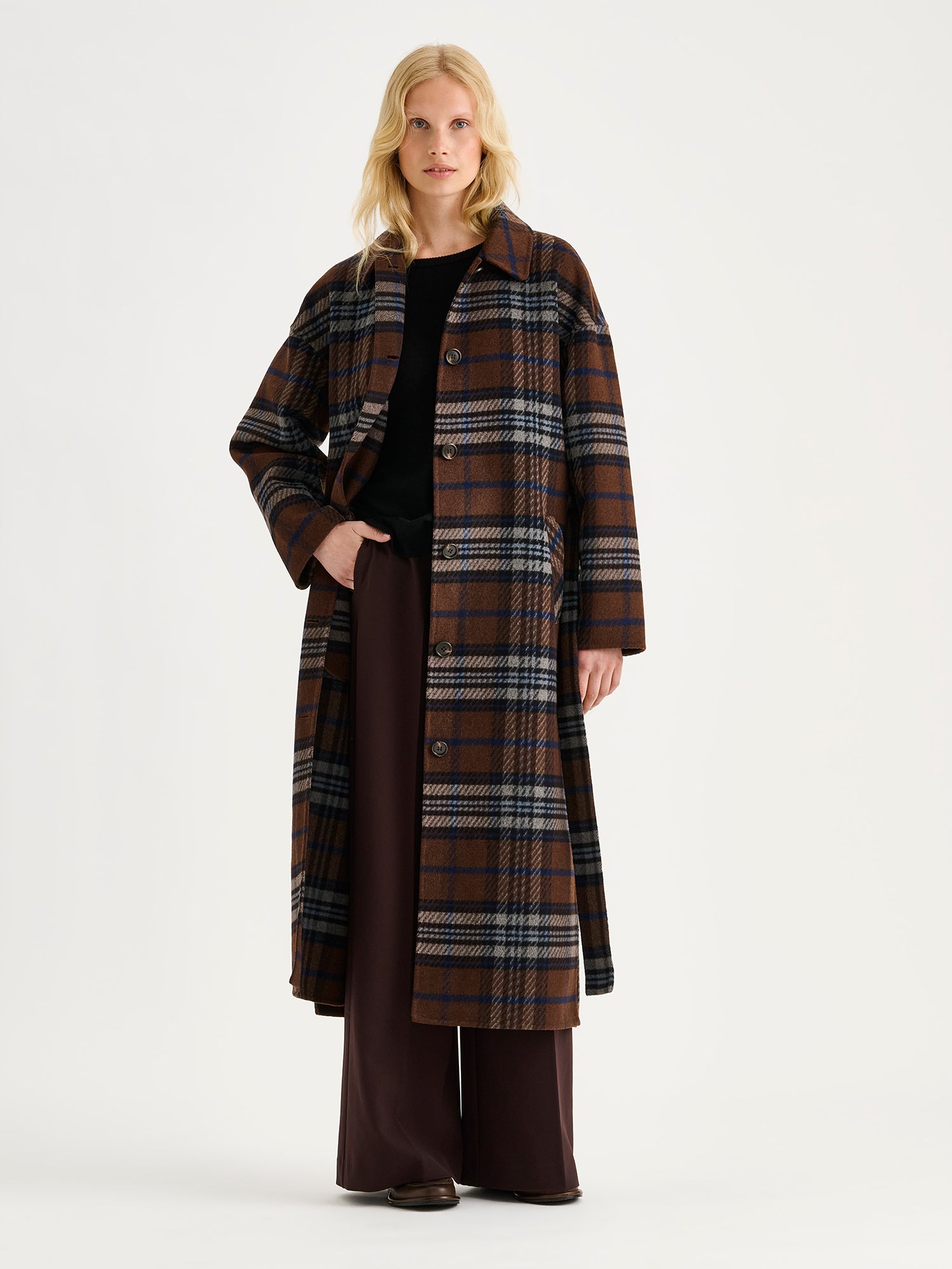 The stylish and timeless Astrid wool coat features a contemporary checked pattern, pictured on a model 