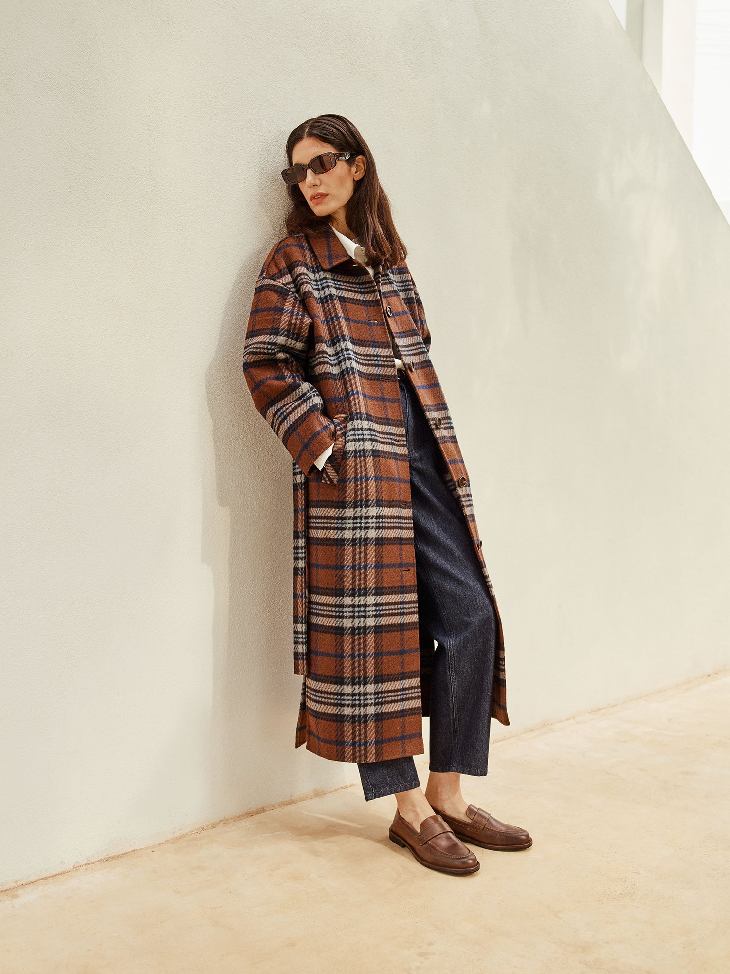 The stylish and timeless Astrid wool coat features a contemporary checked pattern, pictured on a model 