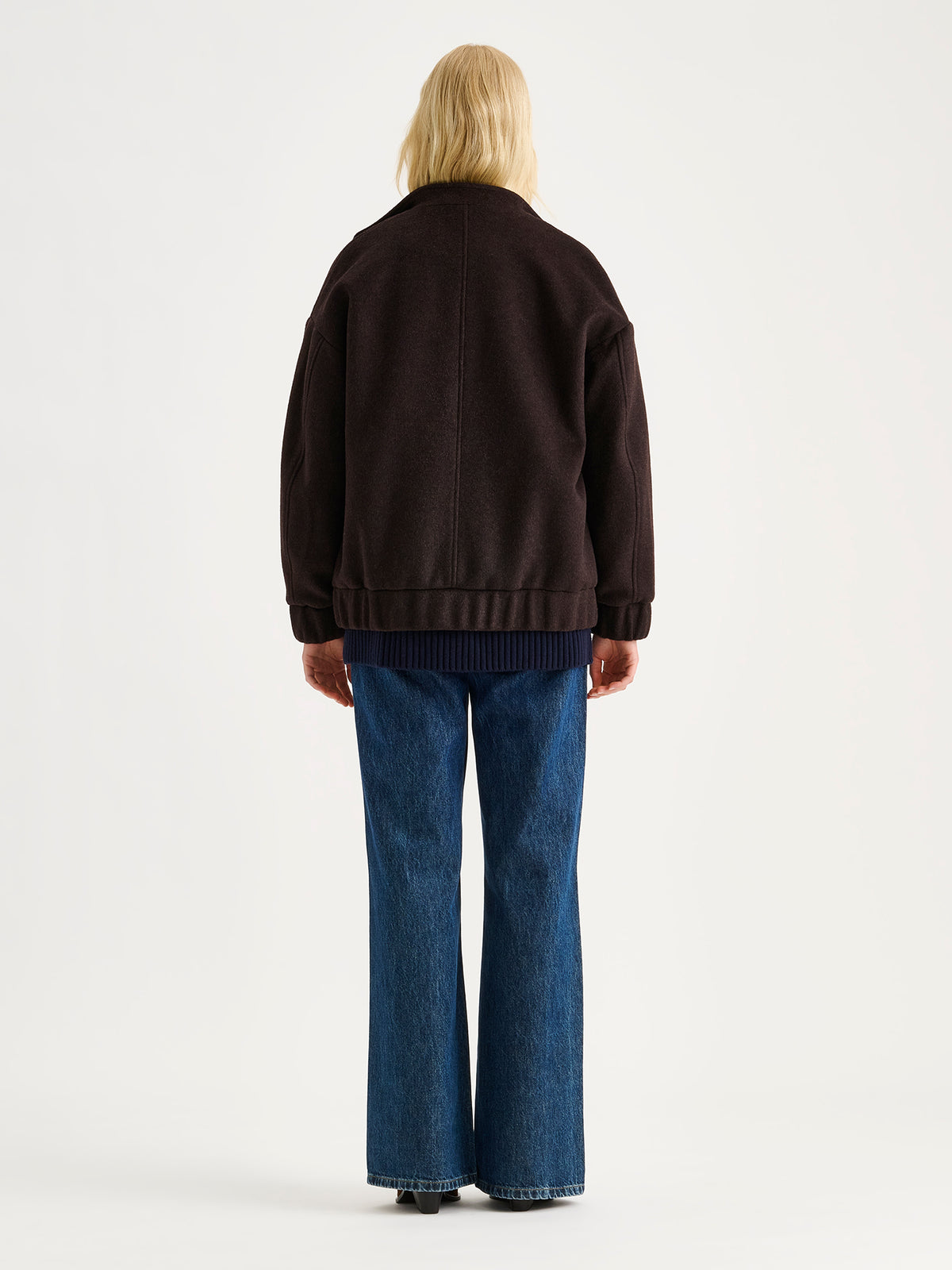 Nanso women's Tove wool bomber jacket in a rich brown shade combines the relaxed look of a bomber jacket with the timeless elegance of wool, on a model.