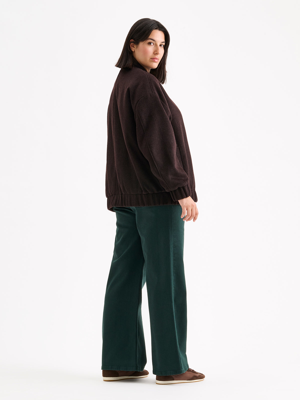 Nanso women's Tove wool bomber jacket in a rich brown shade combines the relaxed look of a bomber jacket with the timeless elegance of wool, on a model.
