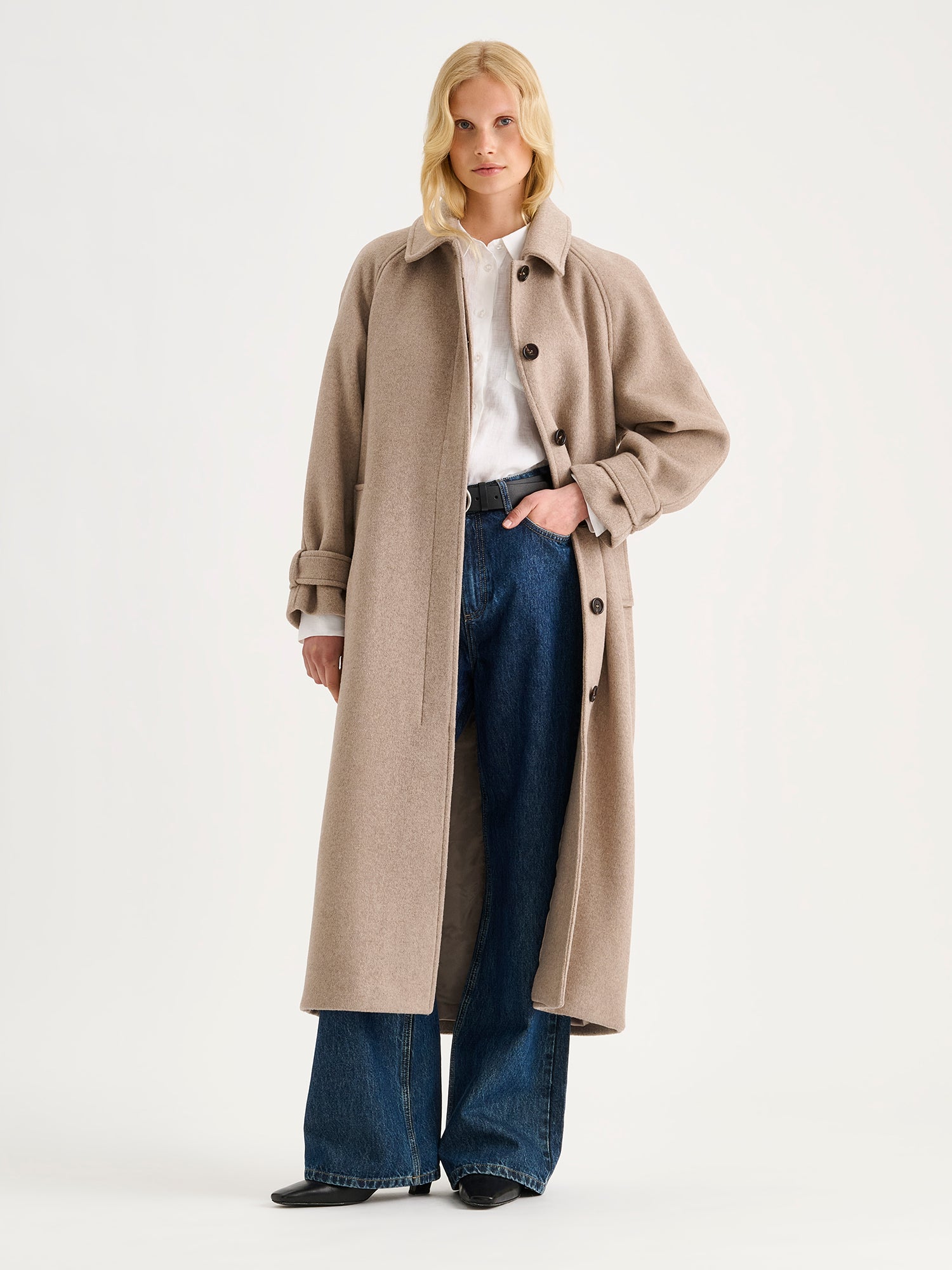 Nanso women's timelessly elegant and effortlessly classic, the Tove long wool coat in beige, on a model with blue jeans