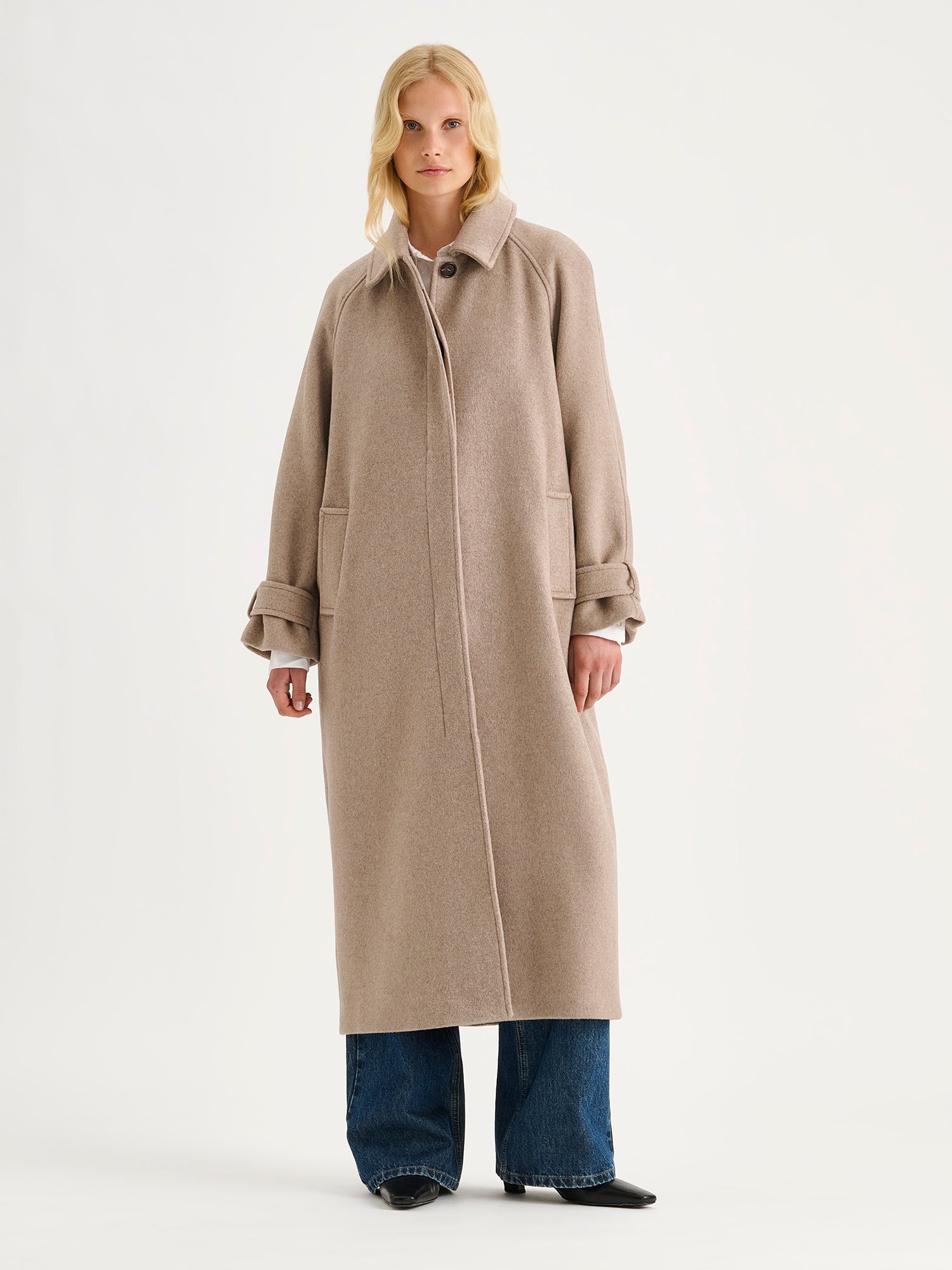 Nanso women's timelessly elegant and effortlessly classic, the Tove long wool coat in beige, on a model with blue jeans