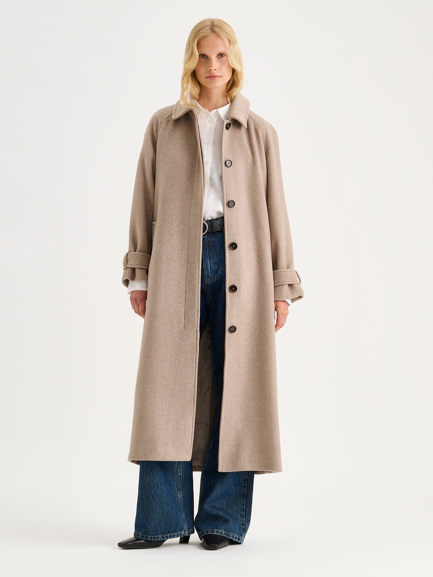 Nanso women's timelessly elegant and effortlessly classic, the Tove long wool coat in beige, on a model with blue jeans