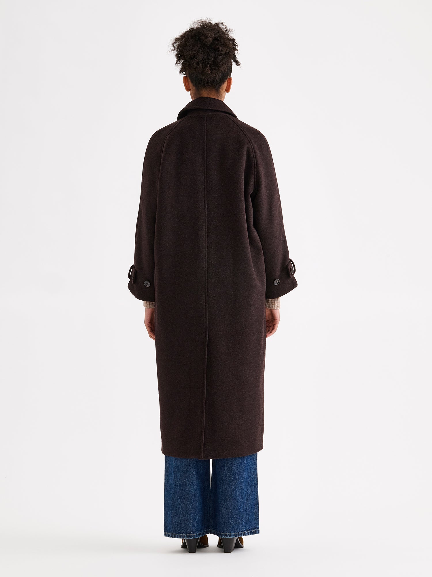 Nanso women's timelessly elegant and effortlessly classic, the Tove long wool coat, on a model with blue jeans, from the backside