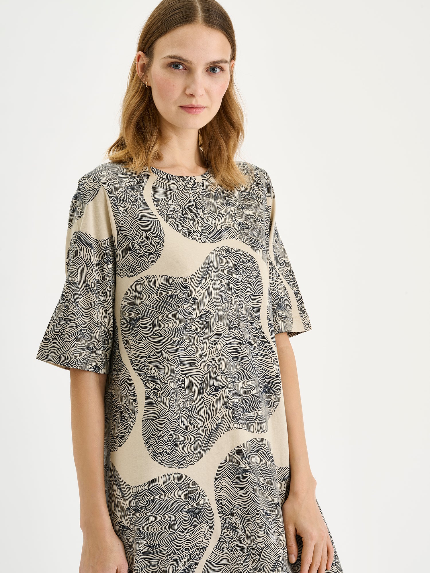 The relaxed, straight-cut Paasi nightdress for women with a harmonious beige-toned print, on a model close-up.
