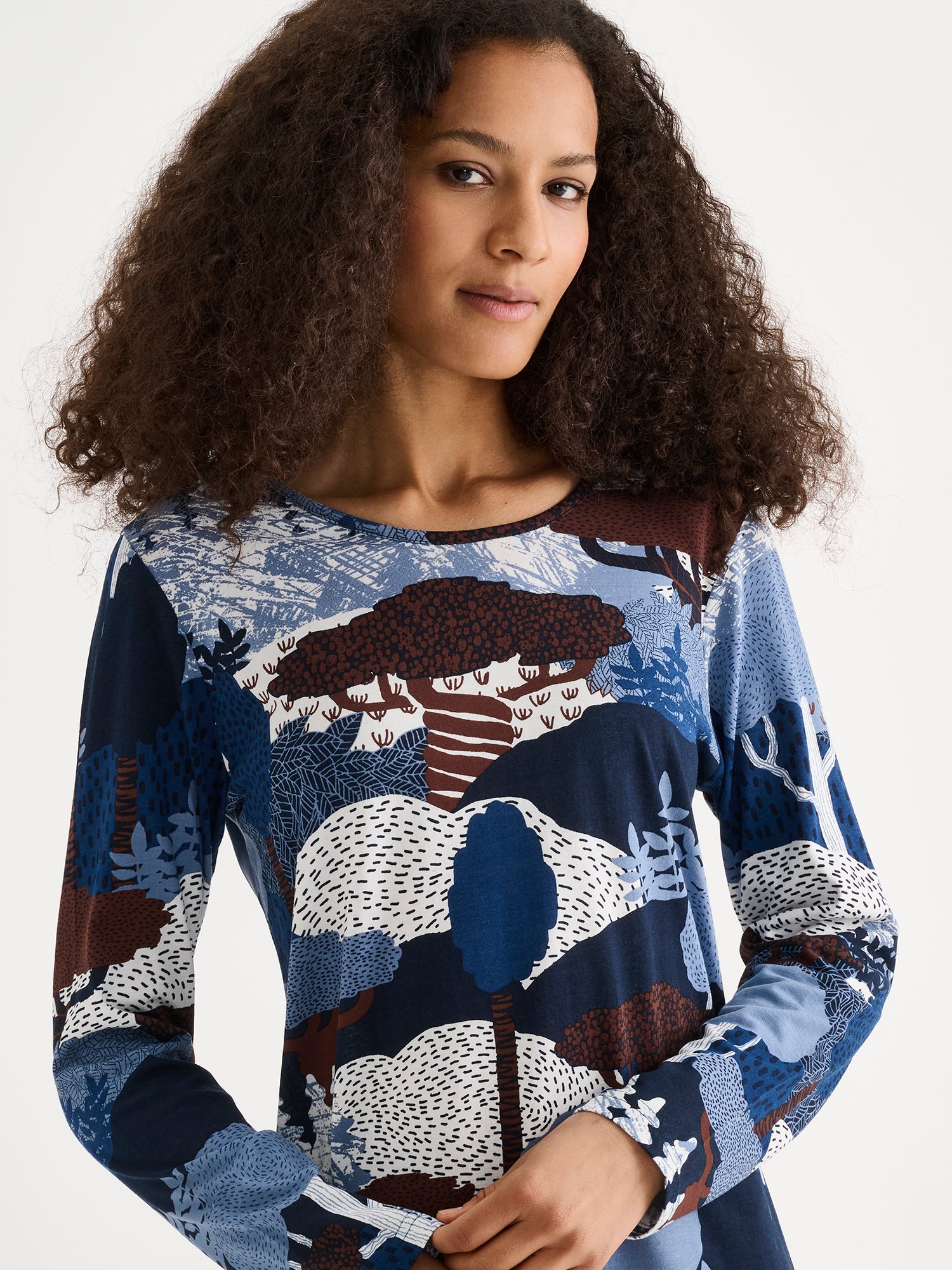 Nanso women's short Ruska nightgown features a beautiful nature-inspired print in harmonious shades of blue and brown. Pictured on a model, close-up.