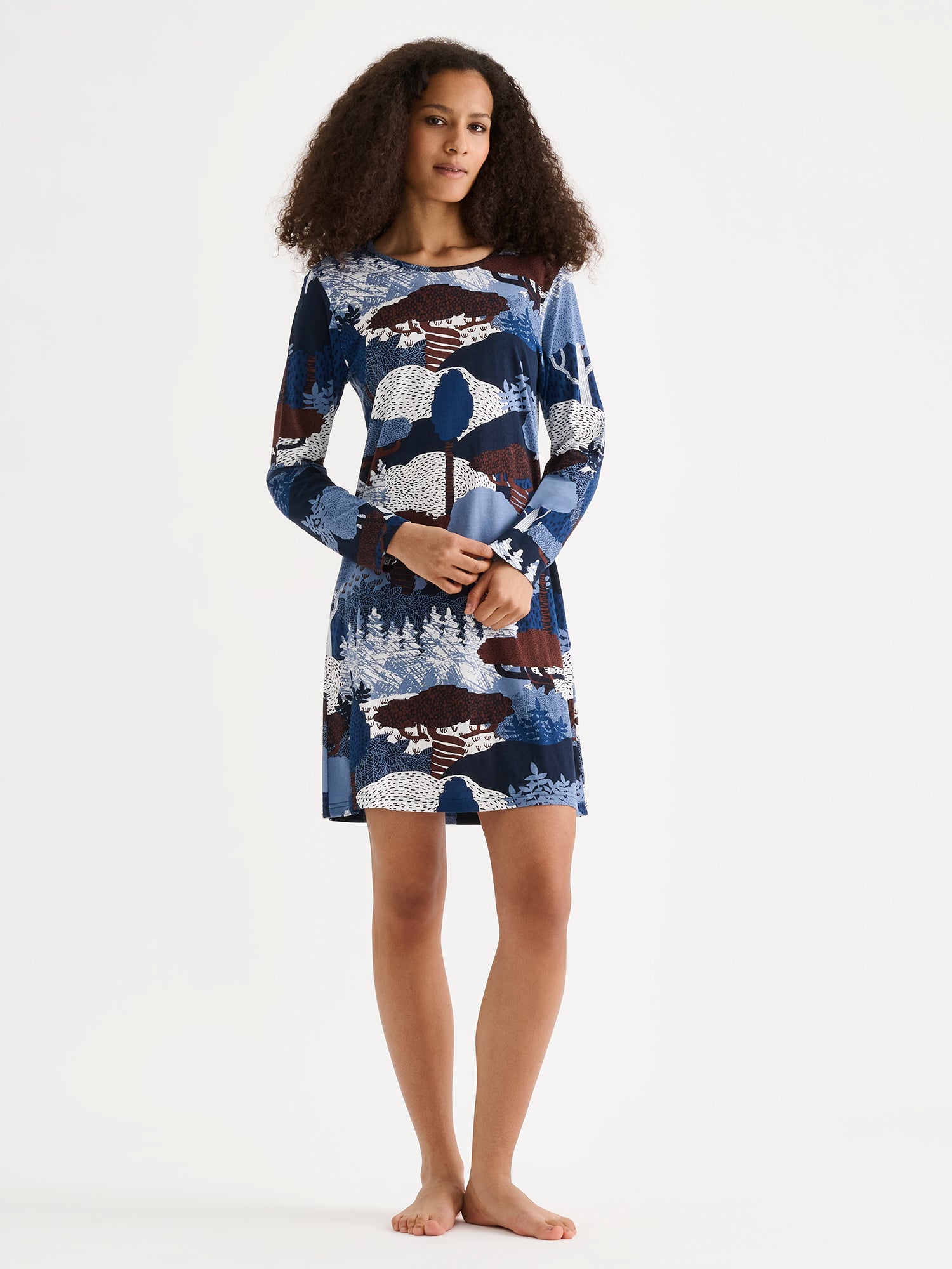 Nanso women's short Ruska nightgown features a beautiful nature-inspired print in harmonious shades of blue and brown. Pictured on a model.