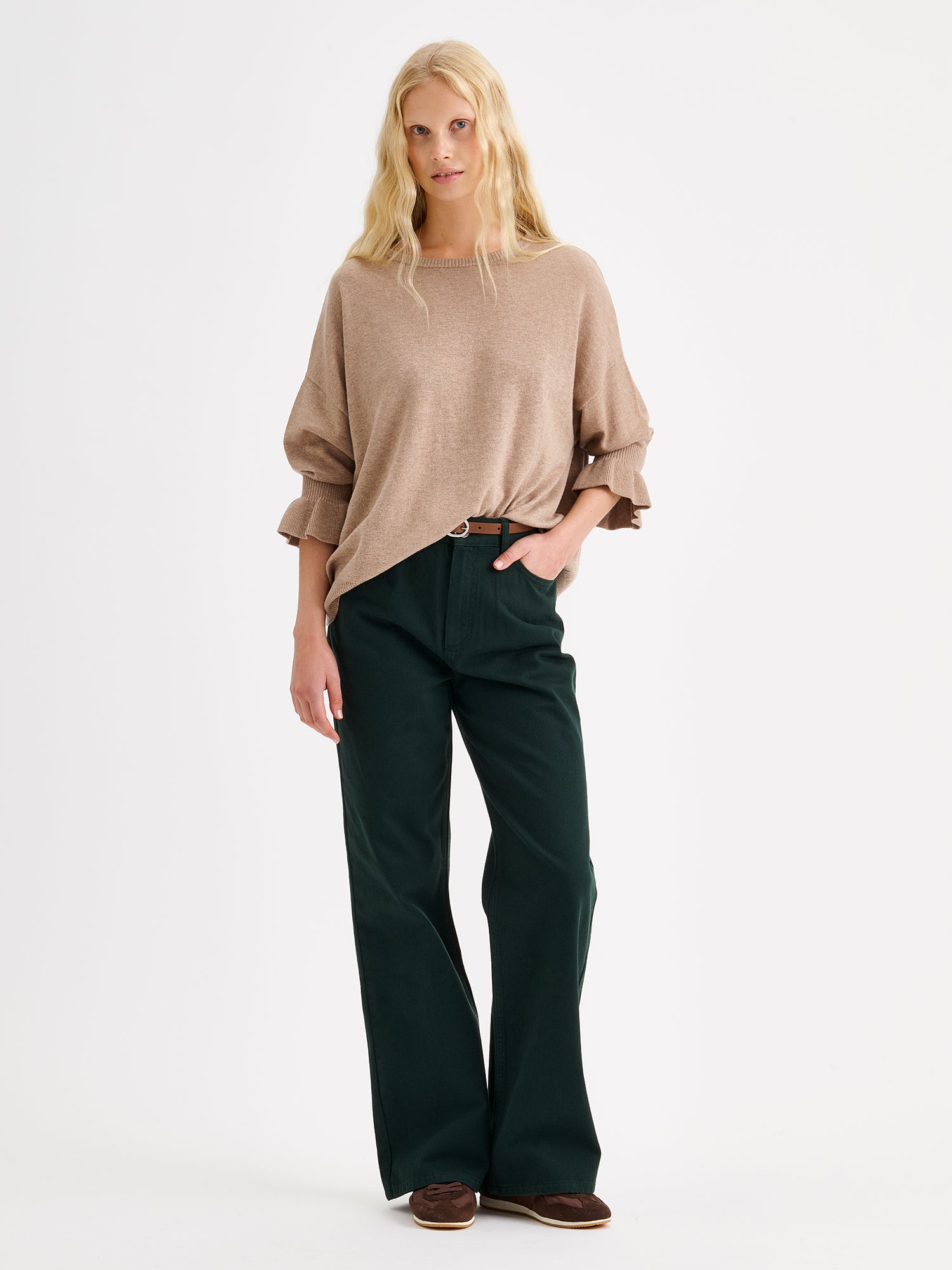 Nanso women's simply stylish and lightweight Villis Frilla knit jumper is charmingly finished with beautiful frill details at the cuffs, pictured on a model with green jeans