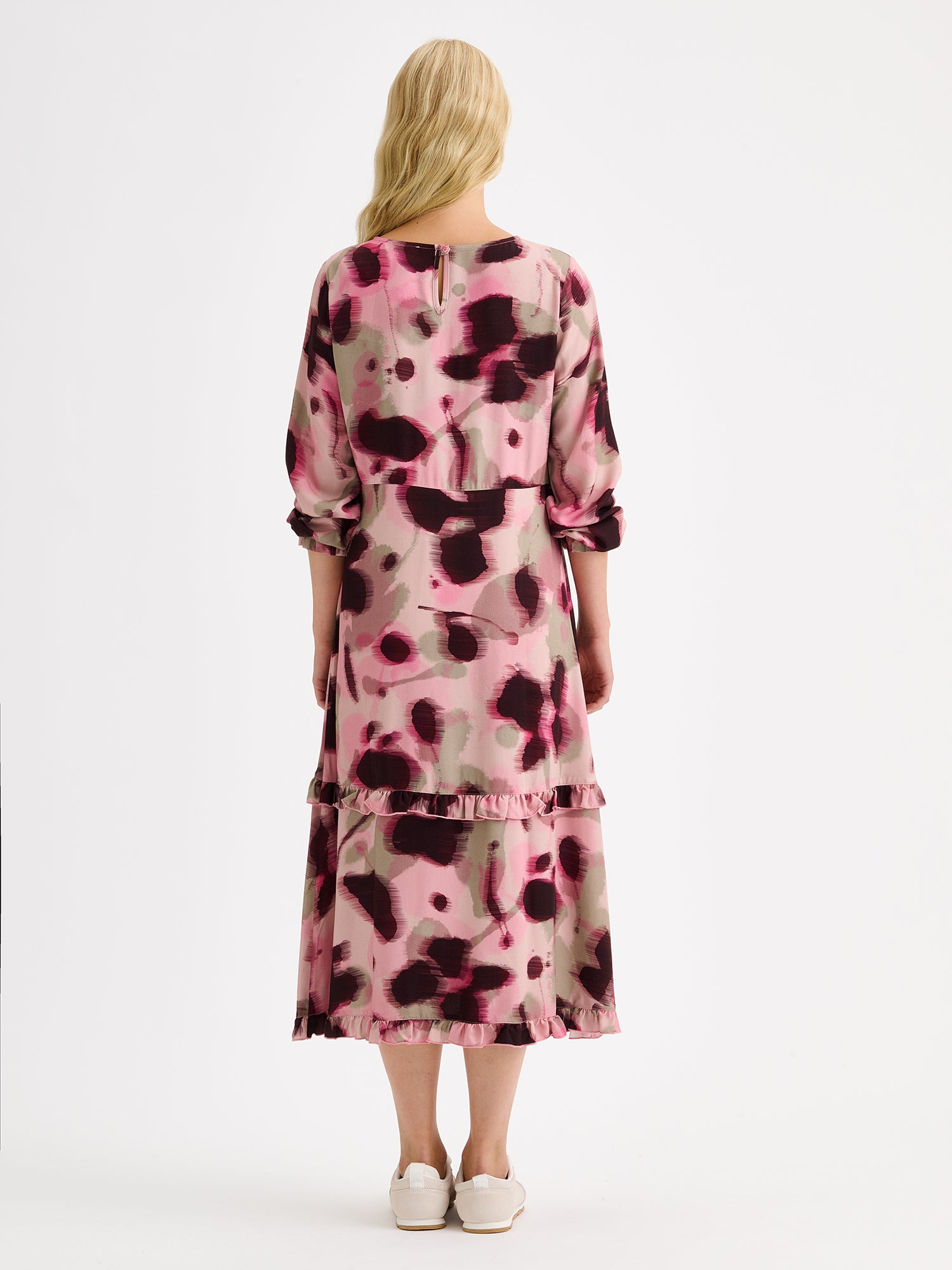 Nanso women's feminine and eye-catching Ruusu midi woven dress is adorned with a painterly print, on a model with sneakers, from the backside