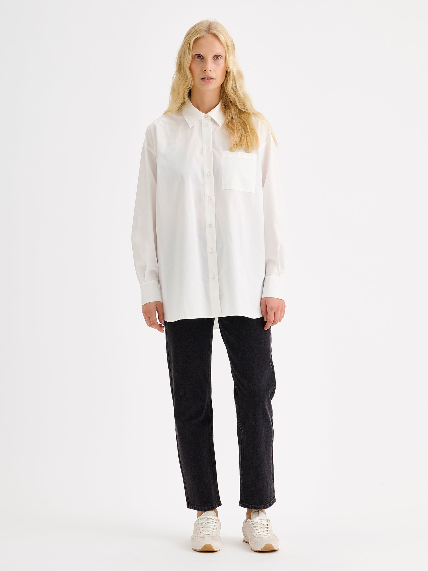 Nanso womens relaxed-fit white Sofi shirt pictured on a model with black jeans