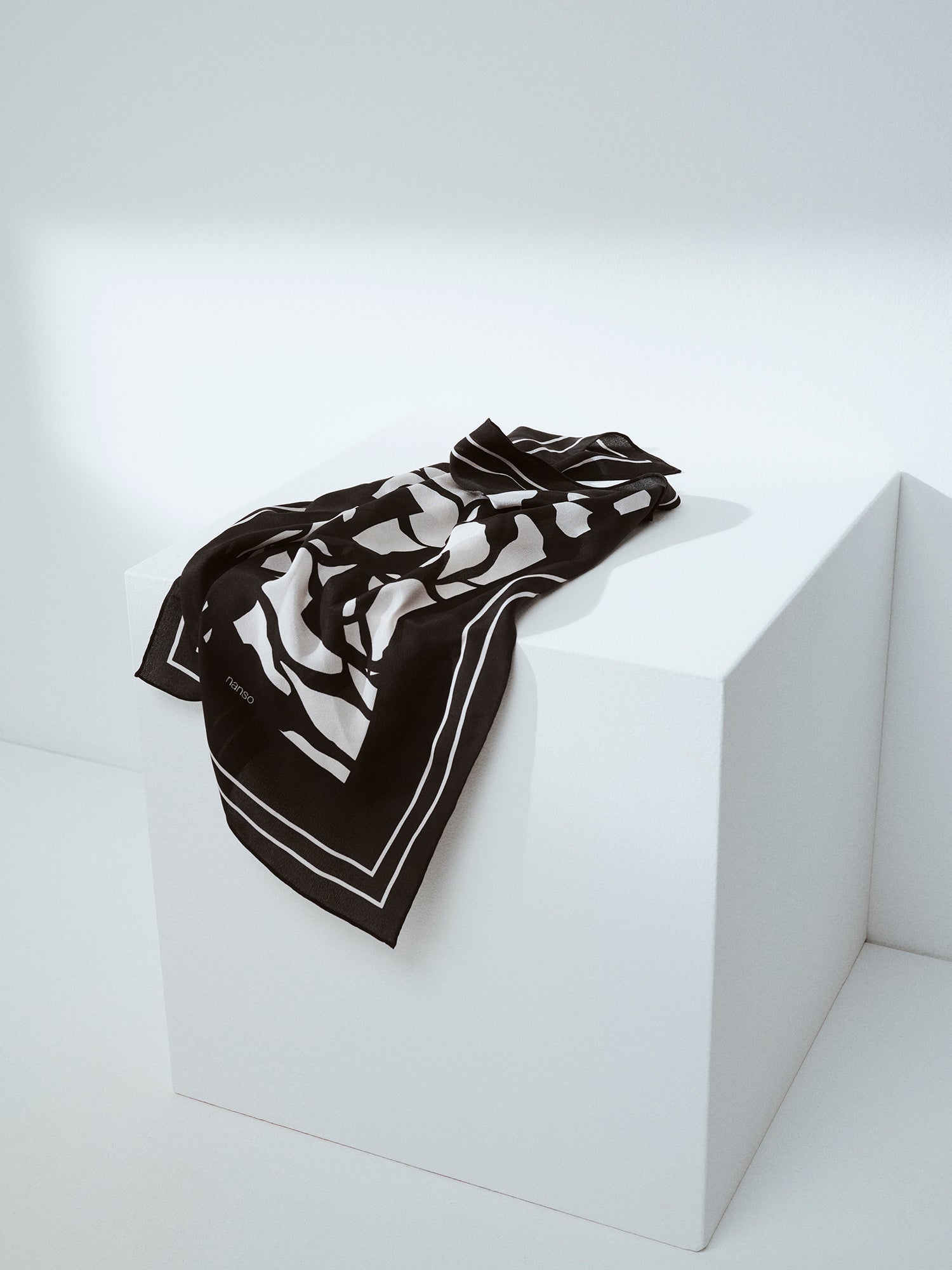 Palsta sophisticated patterned silk scarf in black and white in a product picture.