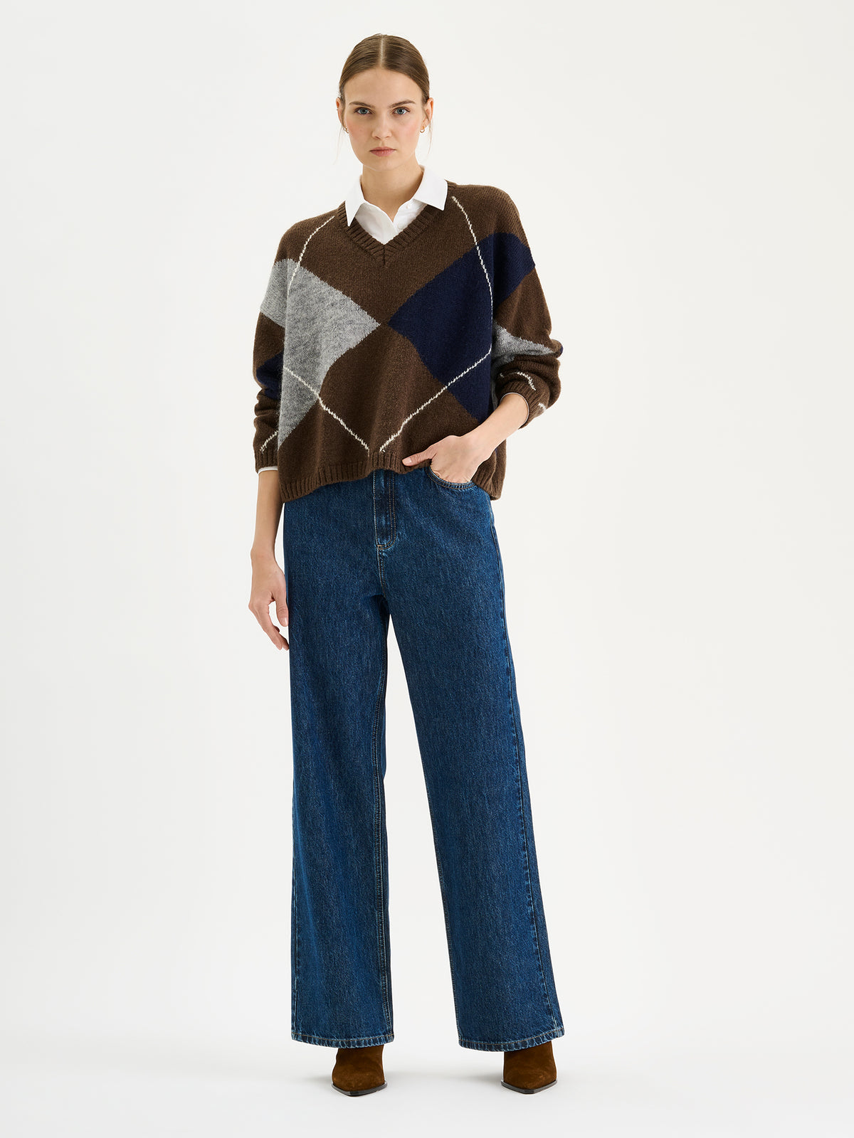 Nanso women's stylish Lotte knit sweater featuring a classic yet on-trend argyle pattern in rich autumnal shades, on a model with jeans.