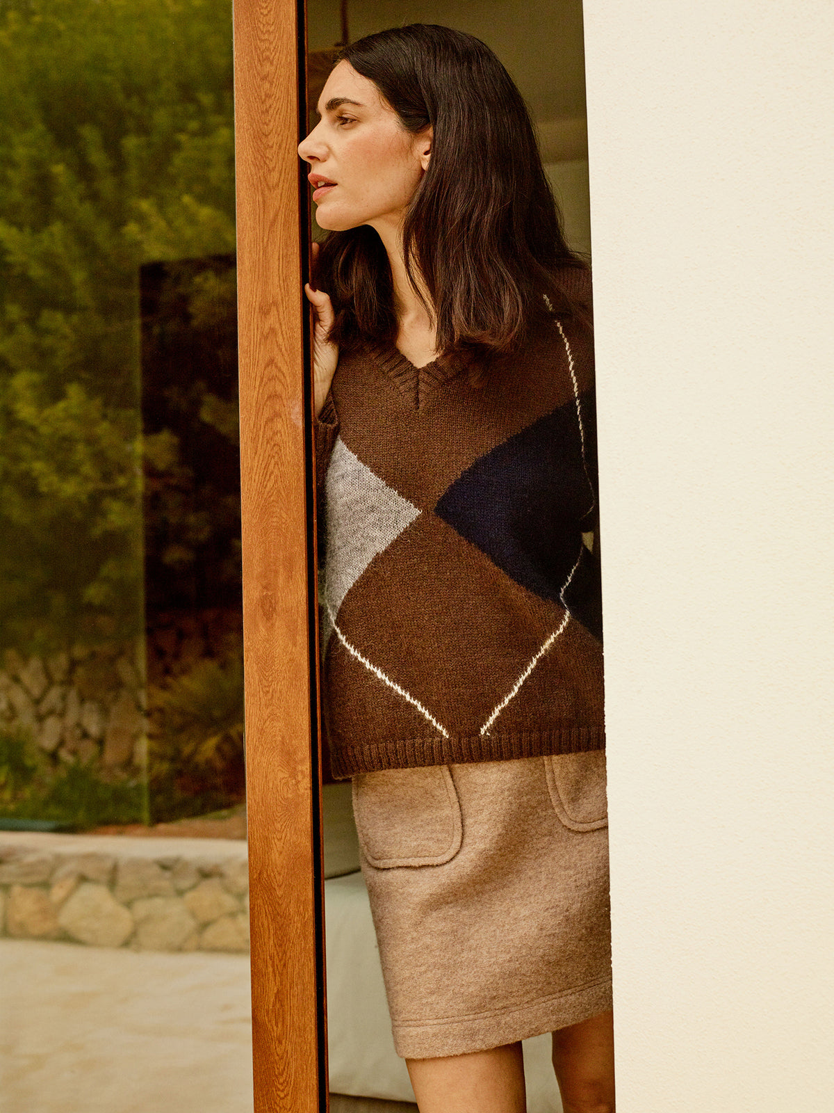 Nanso women's stylish Lotte knit sweater featuring a classic yet on-trend argyle pattern in rich autumnal shades, on a model with a mini skirt.