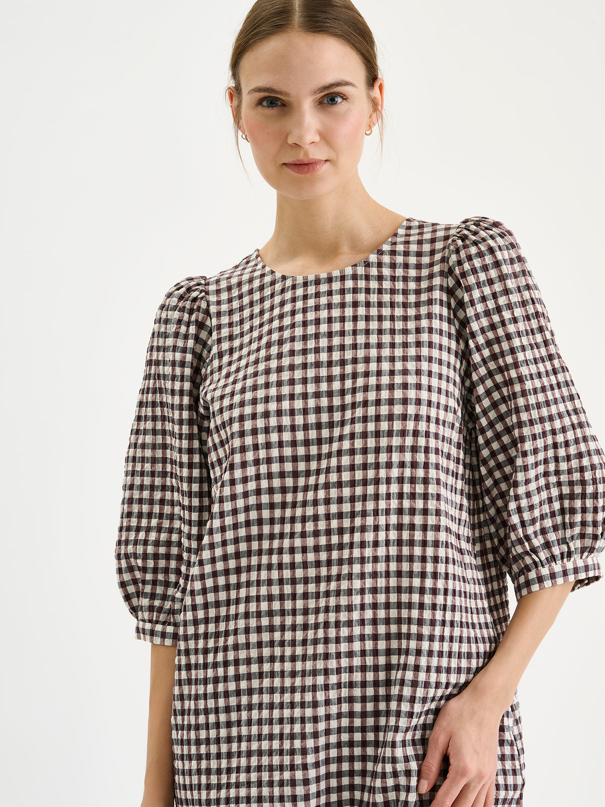 Nanso women's Treffit dress in a timeless brown and white check pattern, on a model close-up.