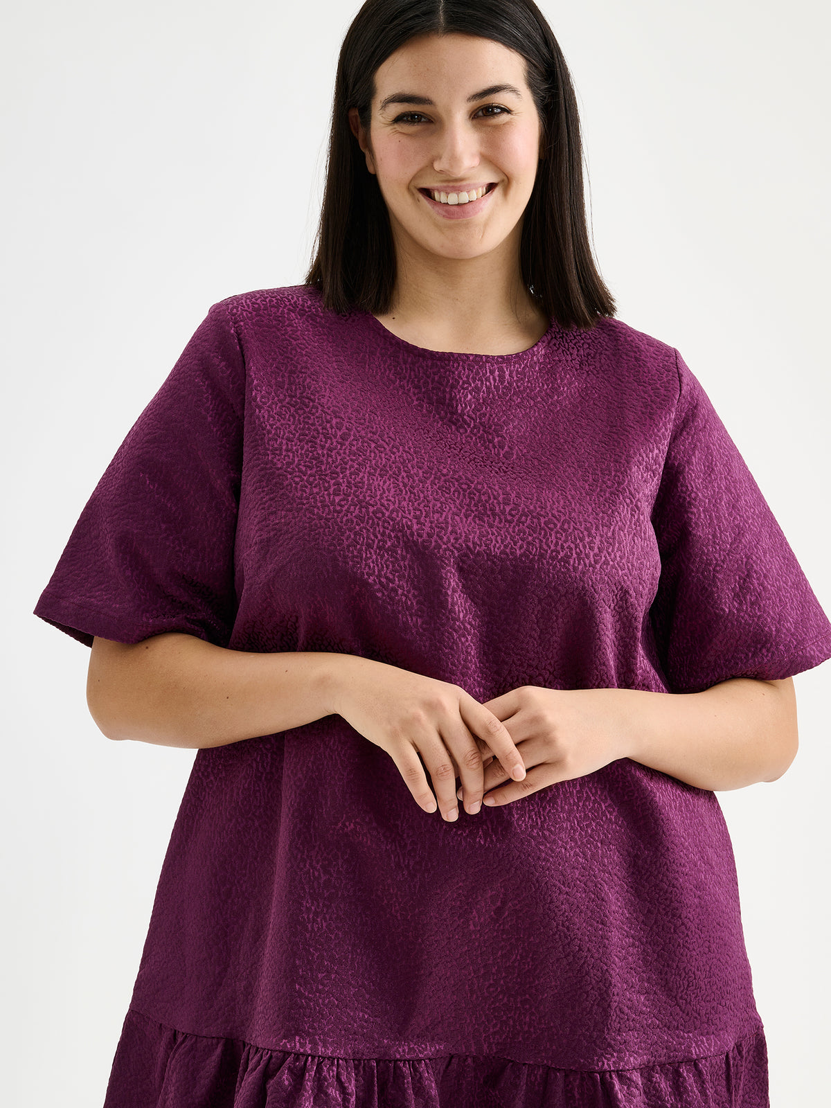 Nanso women's striking Leora dress captivates with its beautiful fabric, combining a festive sheen with a rich textured surface, pictured on a model close-up.