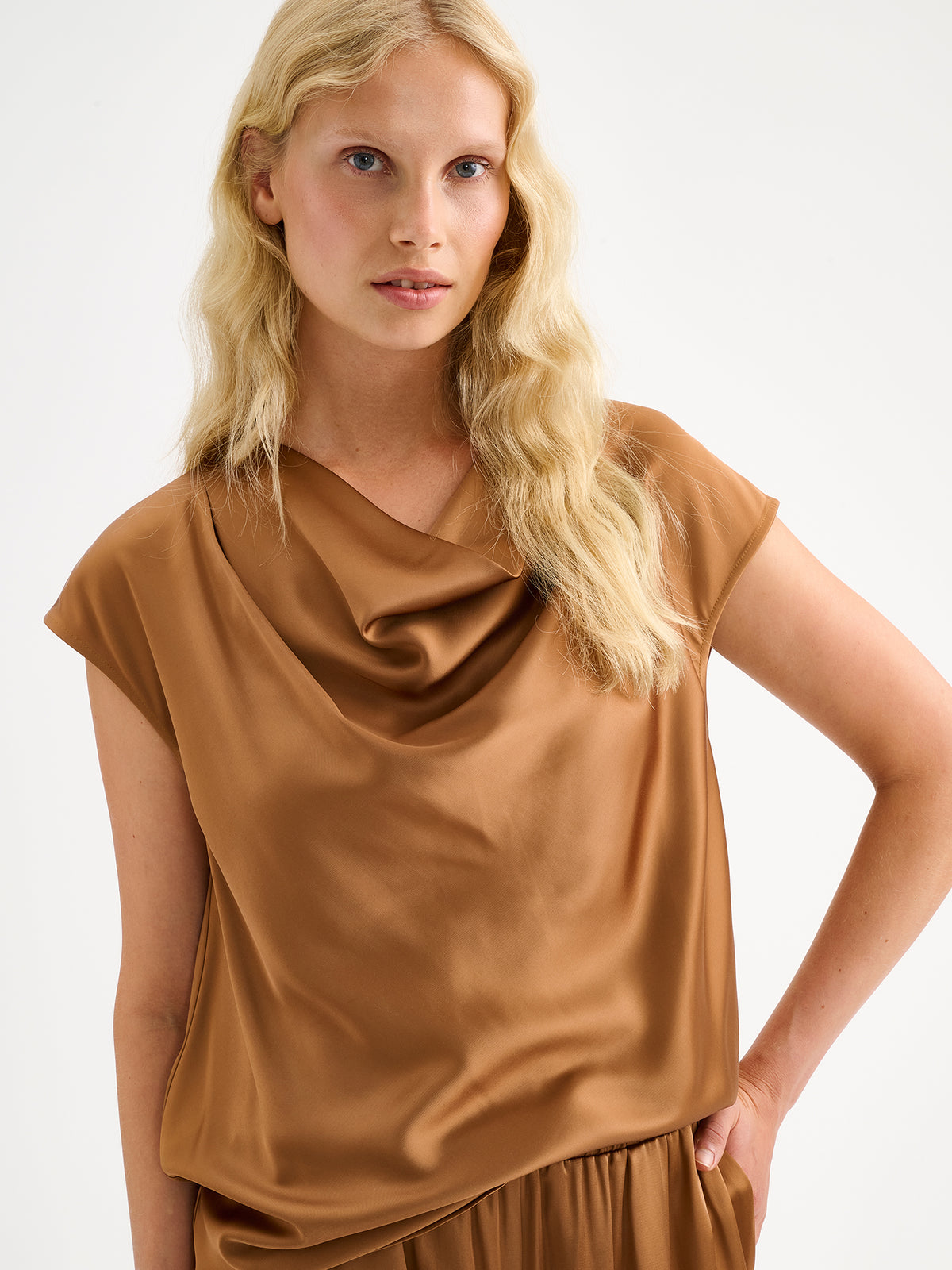 Nanso women's elegant Silva satin blouse in a radiant brown shade is a versatile wardrobe favourite for the season's celebrations. On a model with matching satin trousers.