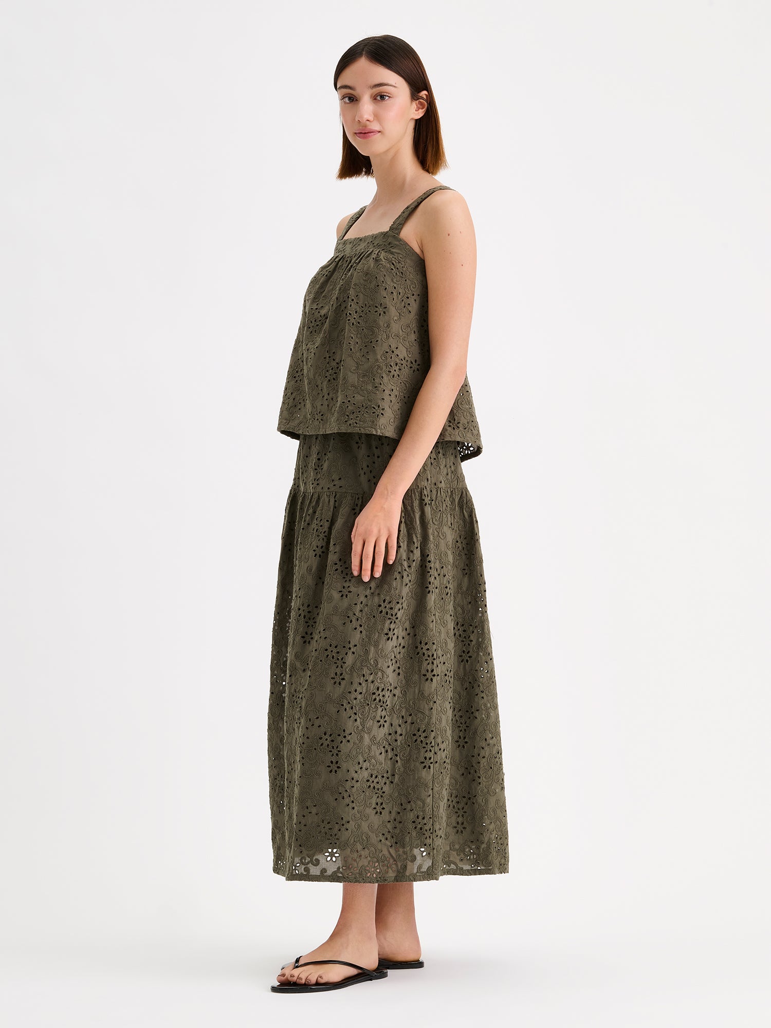 Nanso women's beautiful olive green Odette top for women, crafted from delicate lace-like Broderie anglaise style cotton fabric, on a model with a matching skirt.