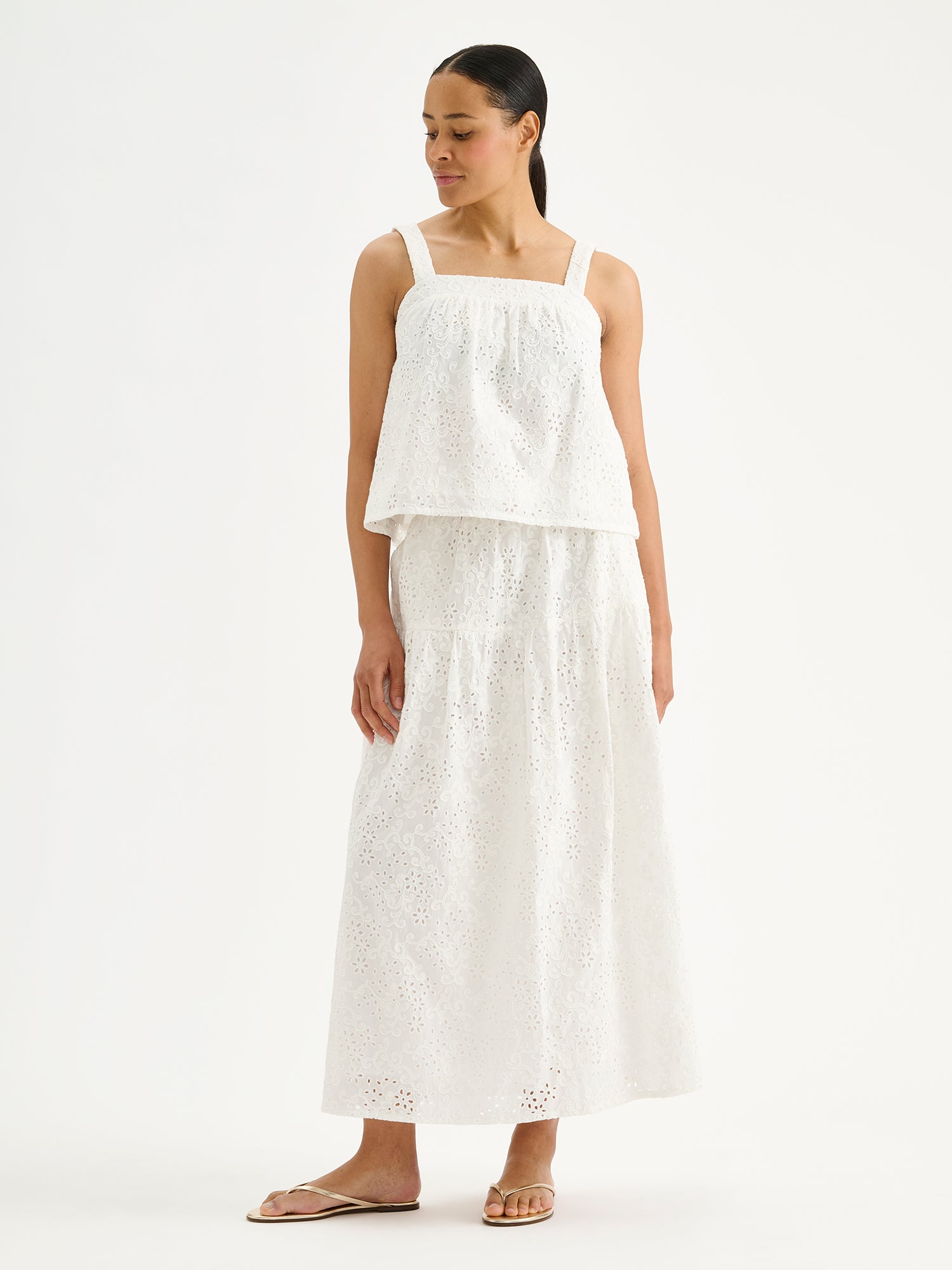 Nanso women's beautiful soft white Odette top for women, crafted from delicate lace-like Broderie anglaise style cotton fabric, on a model with a matching skirt.