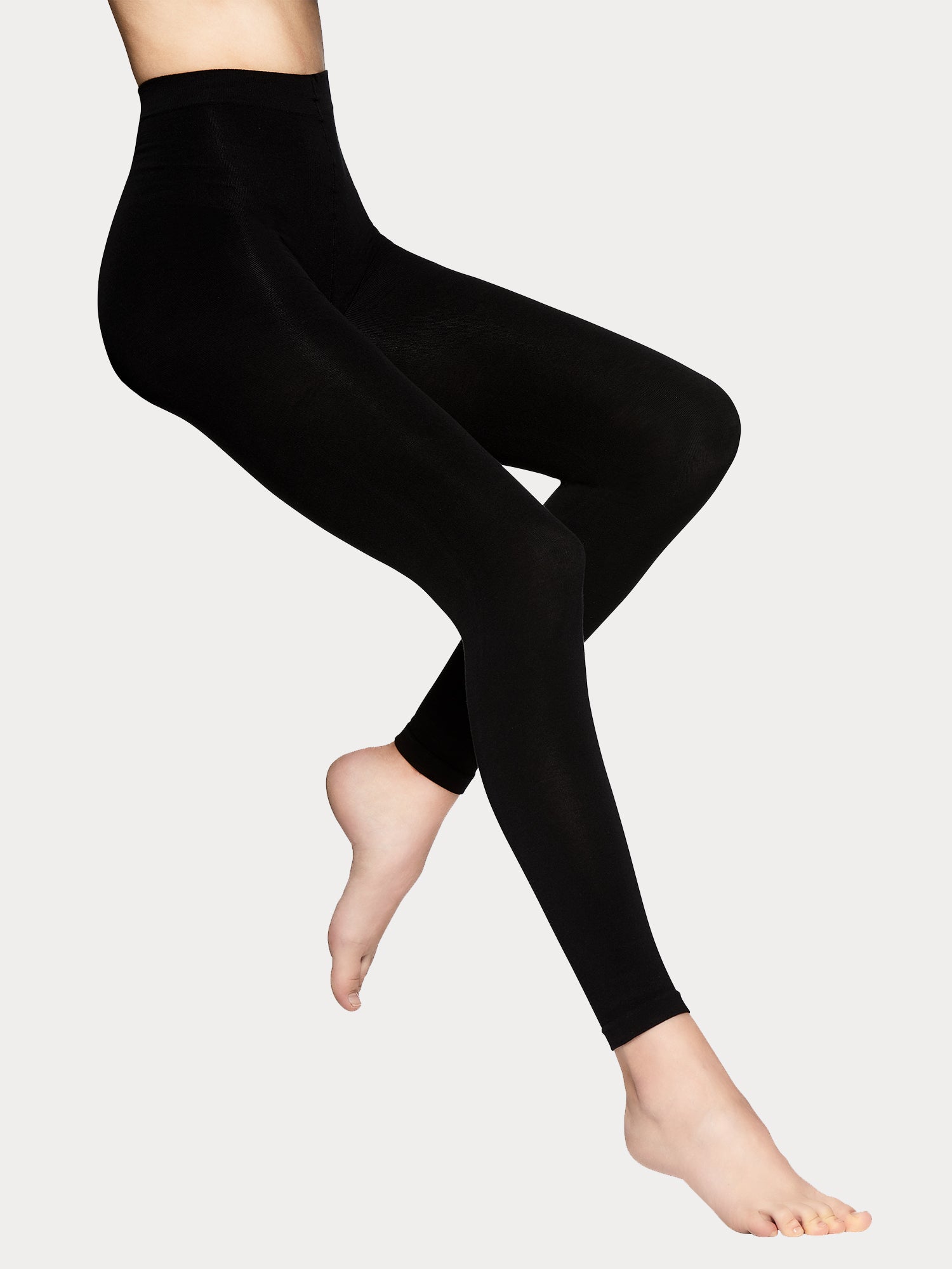 Vogue women's luxuriously soft black Silky Cotton leggings crafted from organic cotton for everyday comfort with innovative 3D knit construction. On a model.