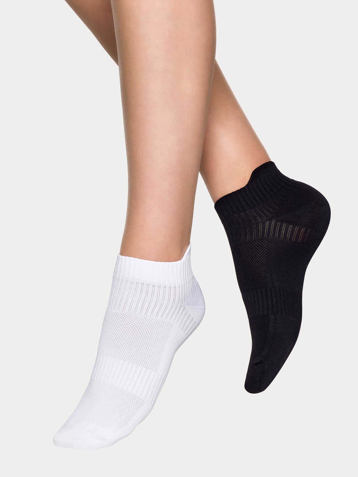 Vogue women's Sport Sneaker socks two-pack combines a black and white pair crafted from polyamide with elastane stretch for all-day comfort, on a model.
