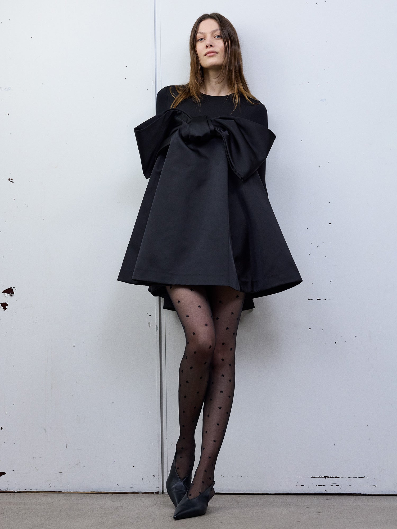 Vogue’s Sofie 40 denier matte black tights worn by the model with a black dress pictured from the front.
