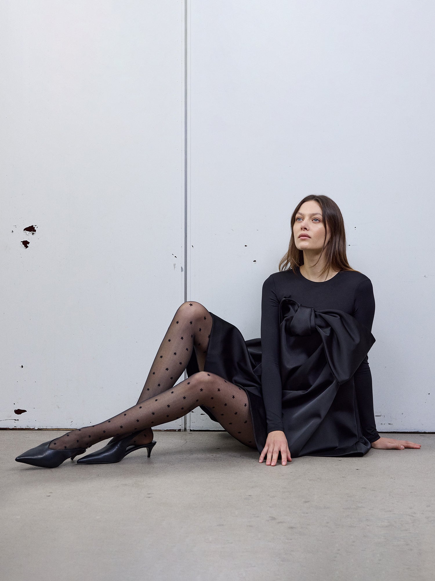 The model is wearing the Sofie black star tights with a black dress and heels. Picture is taken from the front.