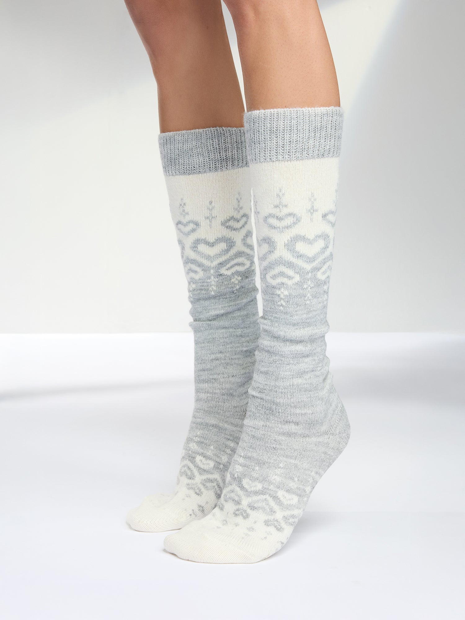 Soft grey-toned wool blend knee-high socks with a charming heart pattern, pictured on a model