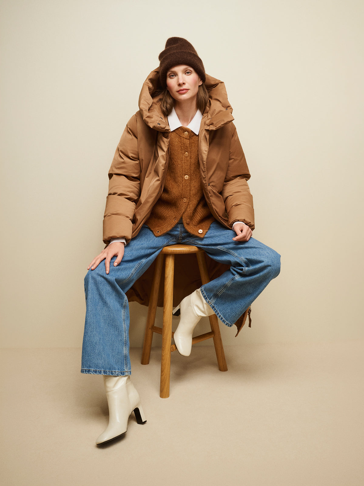 Nanso women's wonderfully warm and luxurious Sumi cardigan enchants with its rich brown hue and beautifully fluffy texture. On a model with  with jeans and a brown long buffer coat.