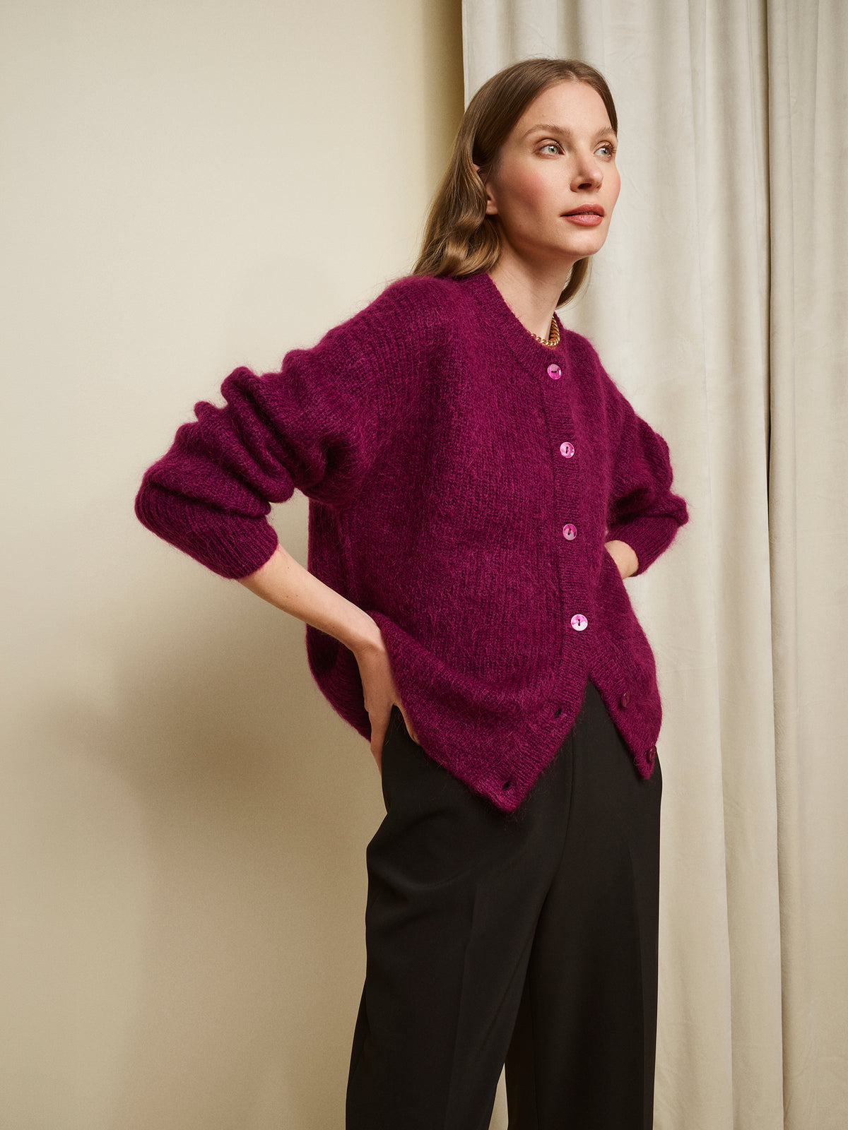 Nanso women's wonderfully warm and luxurious Sumi cardigan enchants with its vibrant violet hue and beautifully fluffy texture, pictured on a model with black trousers. | S - 175,5cm