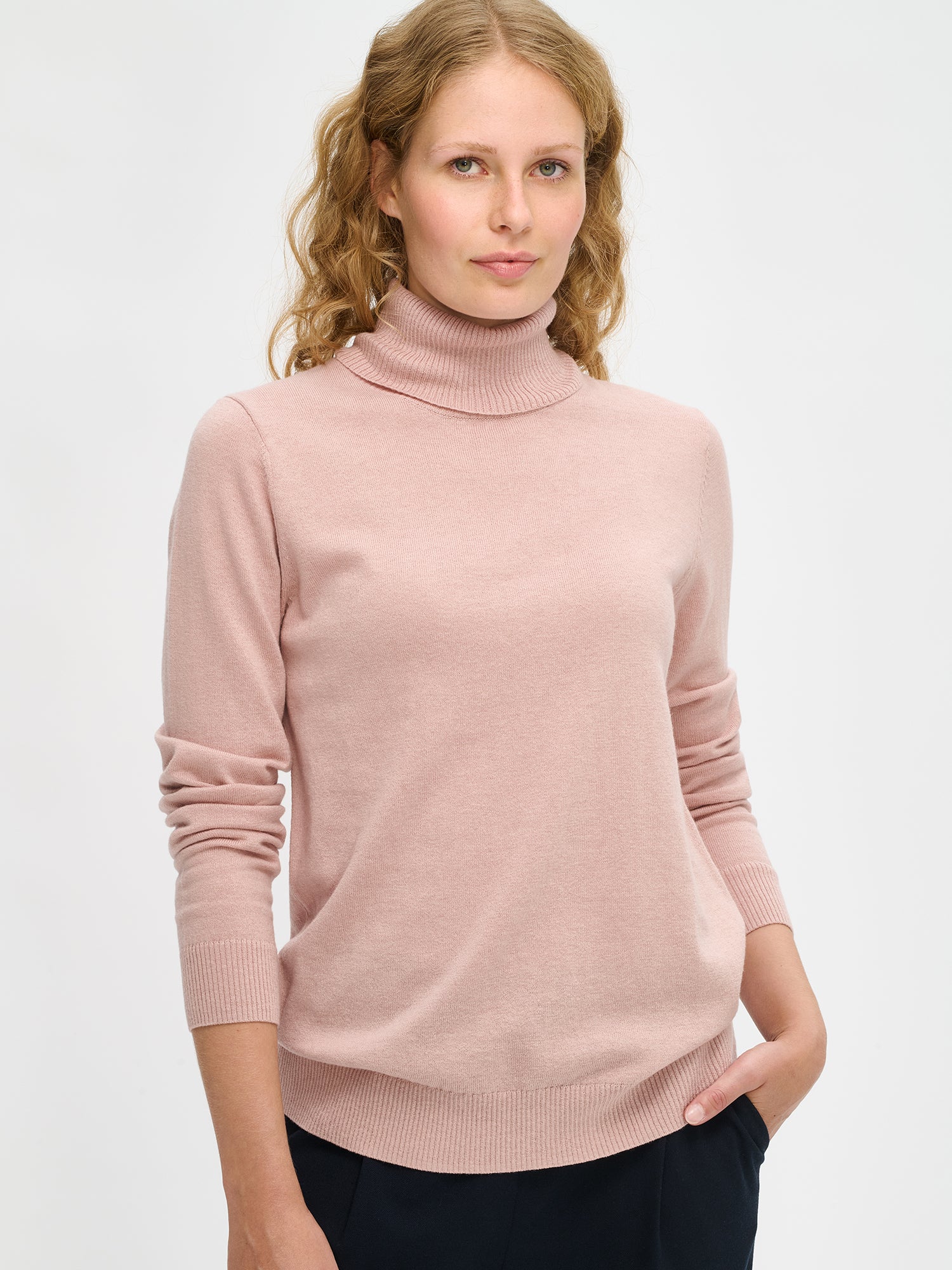 Nanso women’s light pink Villis turtleneck sweater crafted from mulesing-free merino wool and cotton blend, breathable and stylish, worn by model in close-up view.