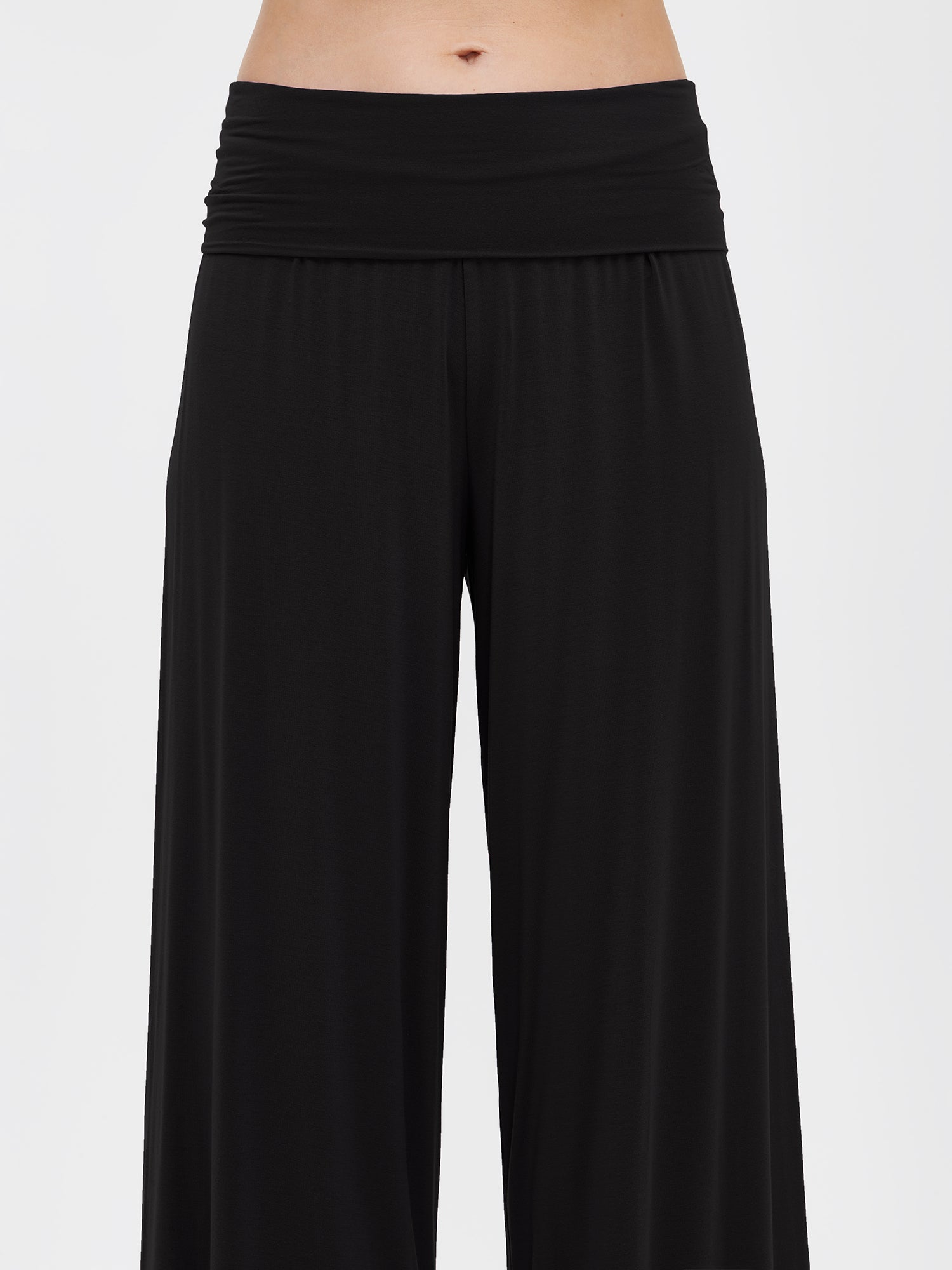 Nanson women's luxuriously soft black 7/8-length Hento pants with a double waistband at the hips, worn by the model, close-up from the front.