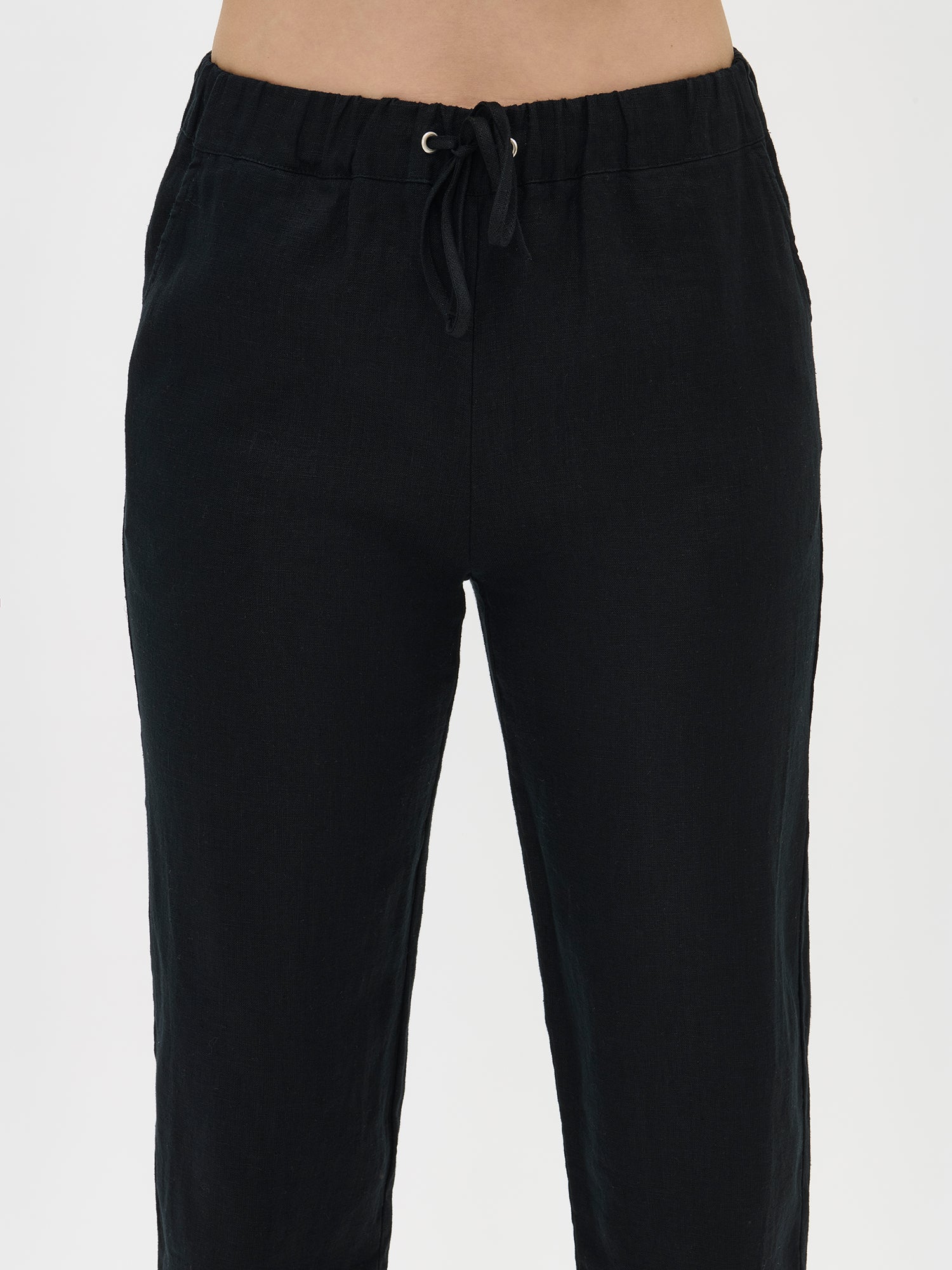 Nanso women’s black Sarastus linen trousers, close-up of the waistband. Elastic waist and drawstring visible.