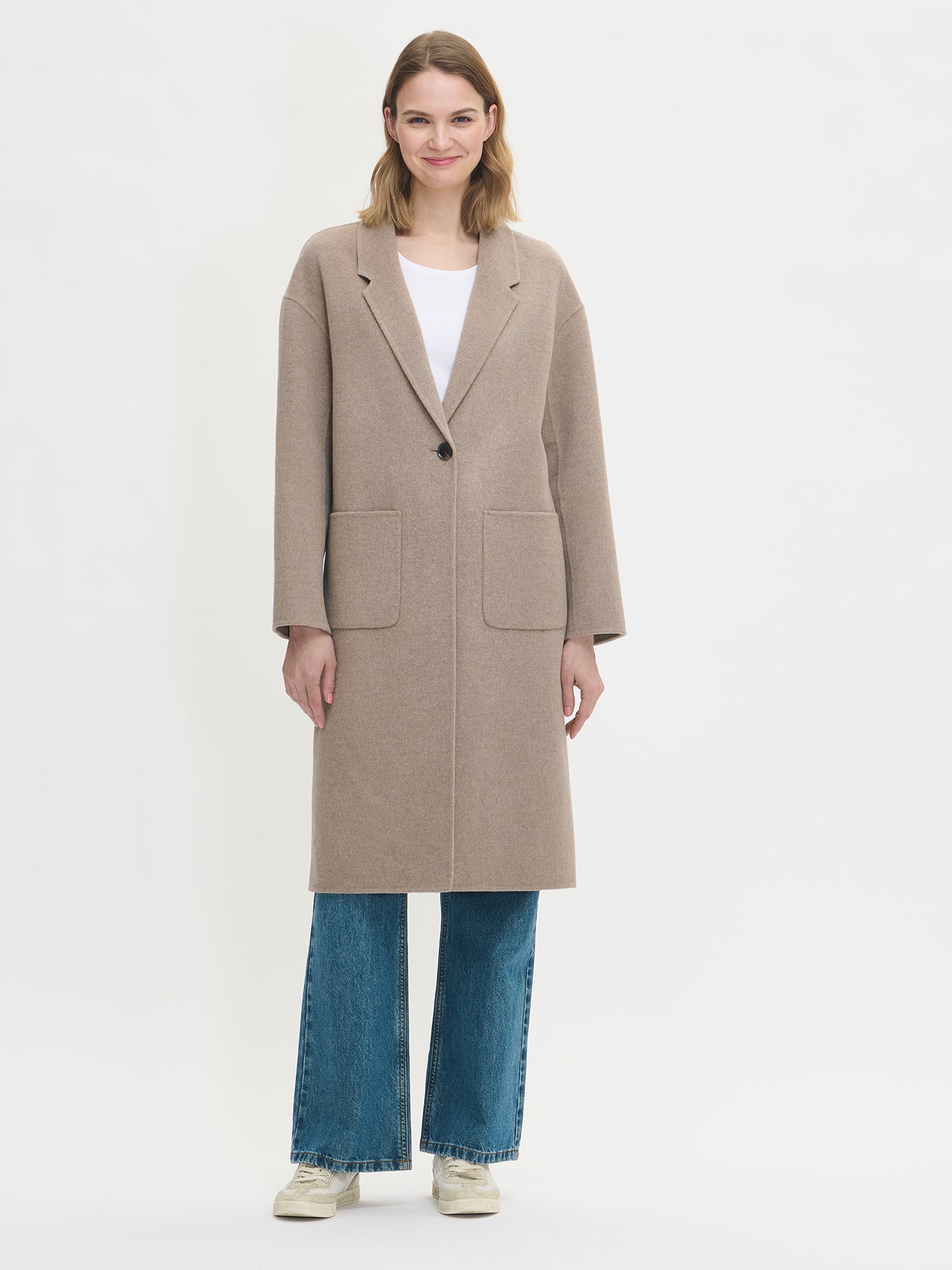 Nanso women's stylish and timeless beige YLLE wool coat. On a model from the front closed