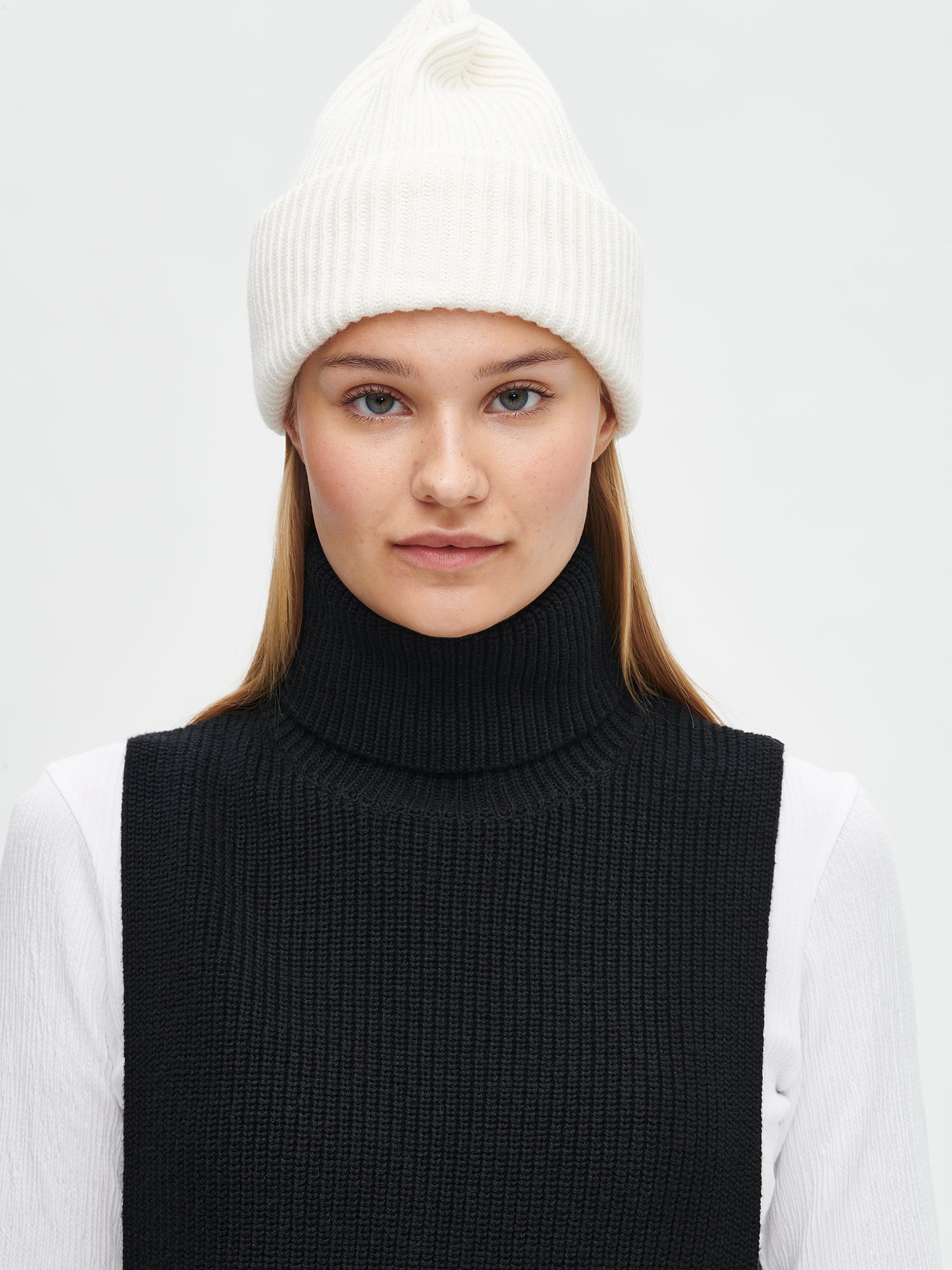 Women's black Utu turtle scarf is crafted from a comfortable patent knit and features a foldable turtle collar.  On a model.