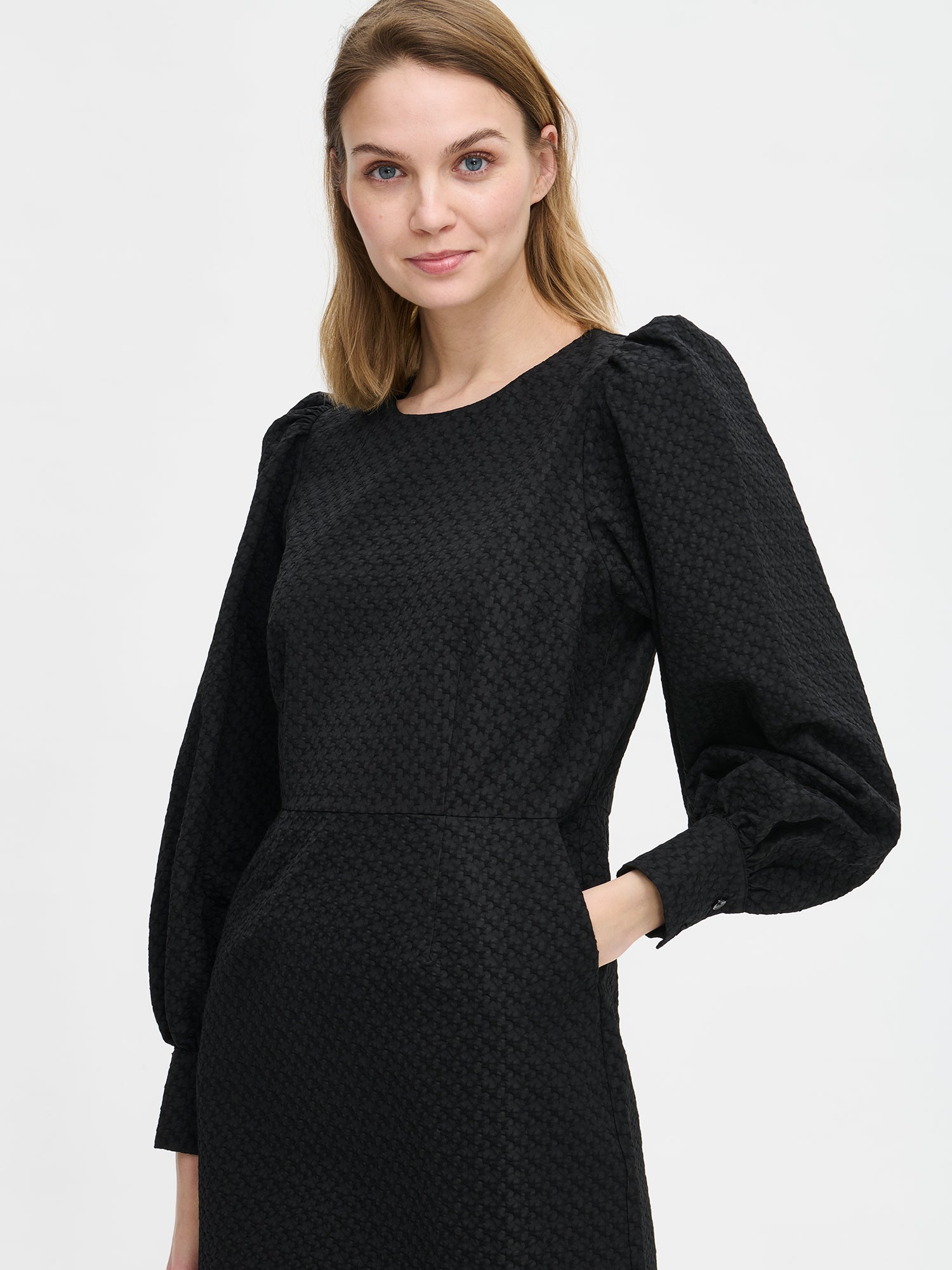 Nanso's elegant black Reliefi dress. On a model in size 36, front close-up
