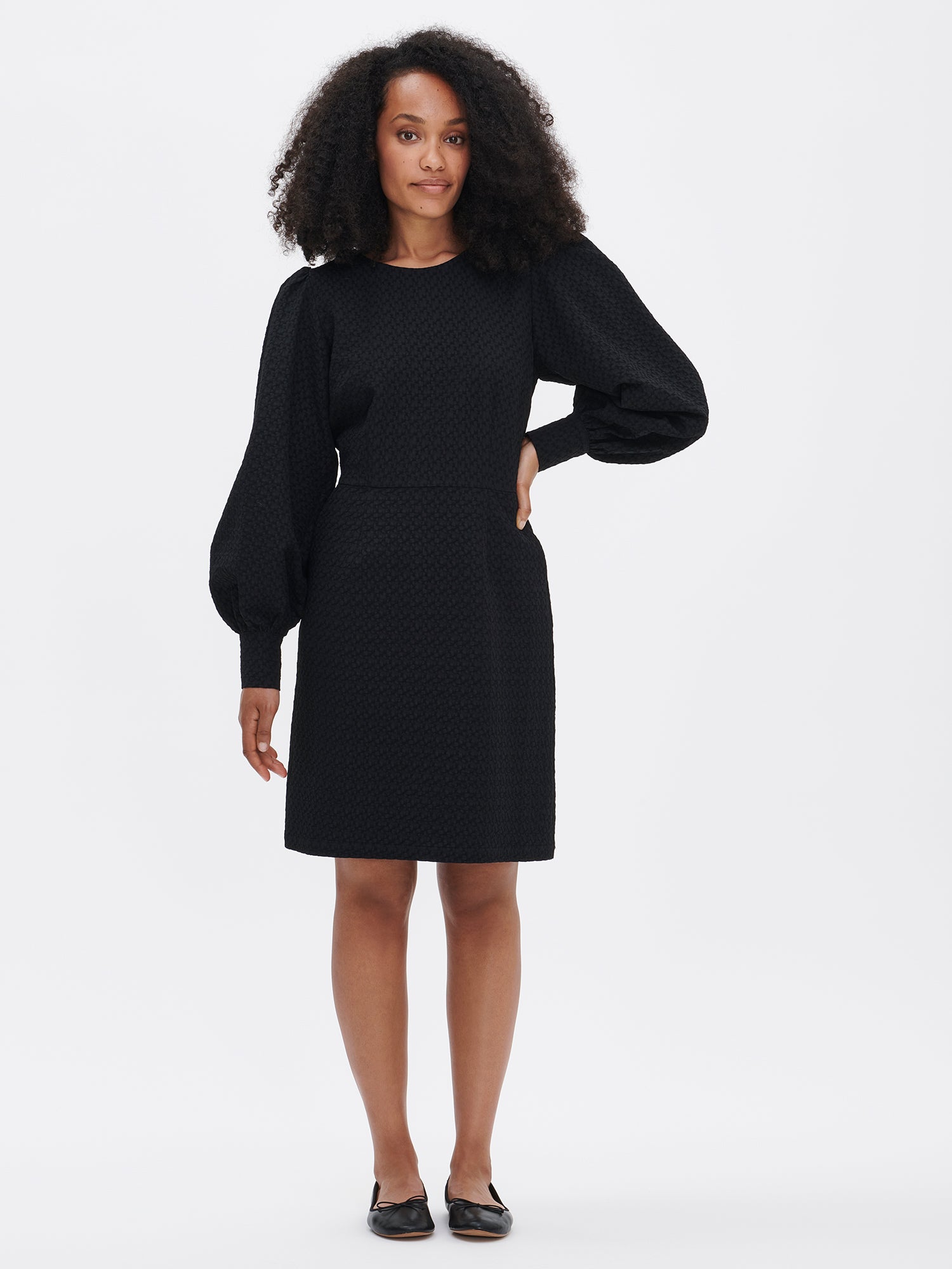 Nanso's elegant black Reliefi dress. On a model in size 36, front