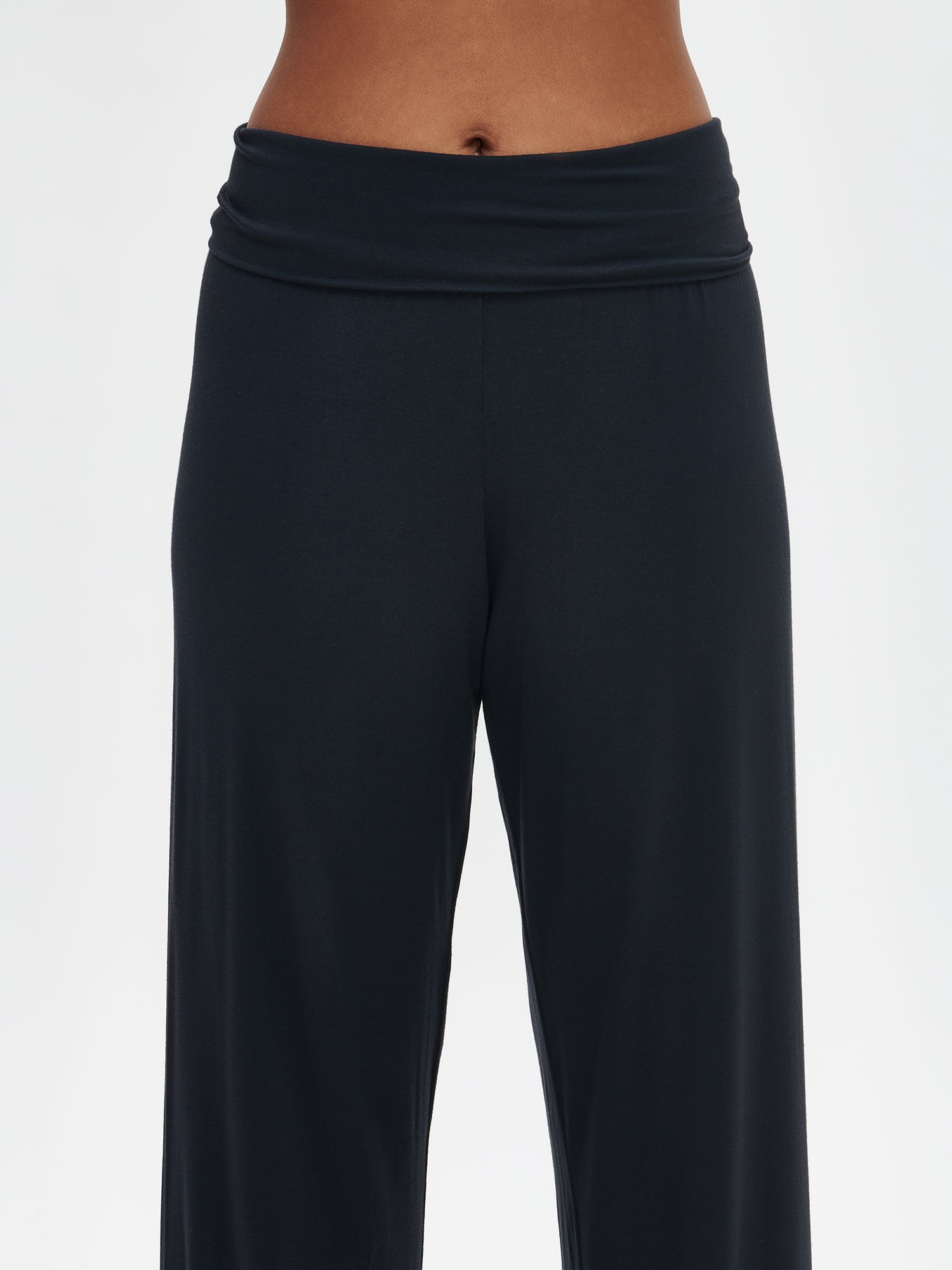 Nanson women's luxuriously soft black Pitsi pants, with timeless lace ribbons on the hems, paired with the matching Pitsi top from the same collection, worn by the model in a close-up front view.