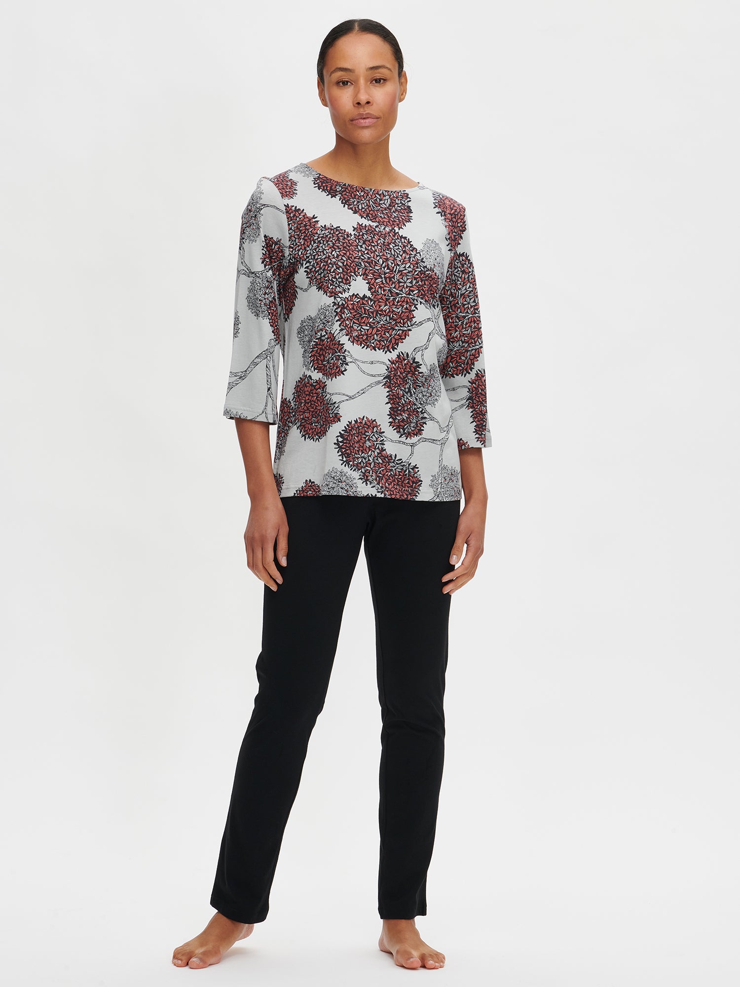 Nanso women’s patterned grey Tuomi pyjama with 3/4 length sleeves and an oval neckline, worn by the model from the front.